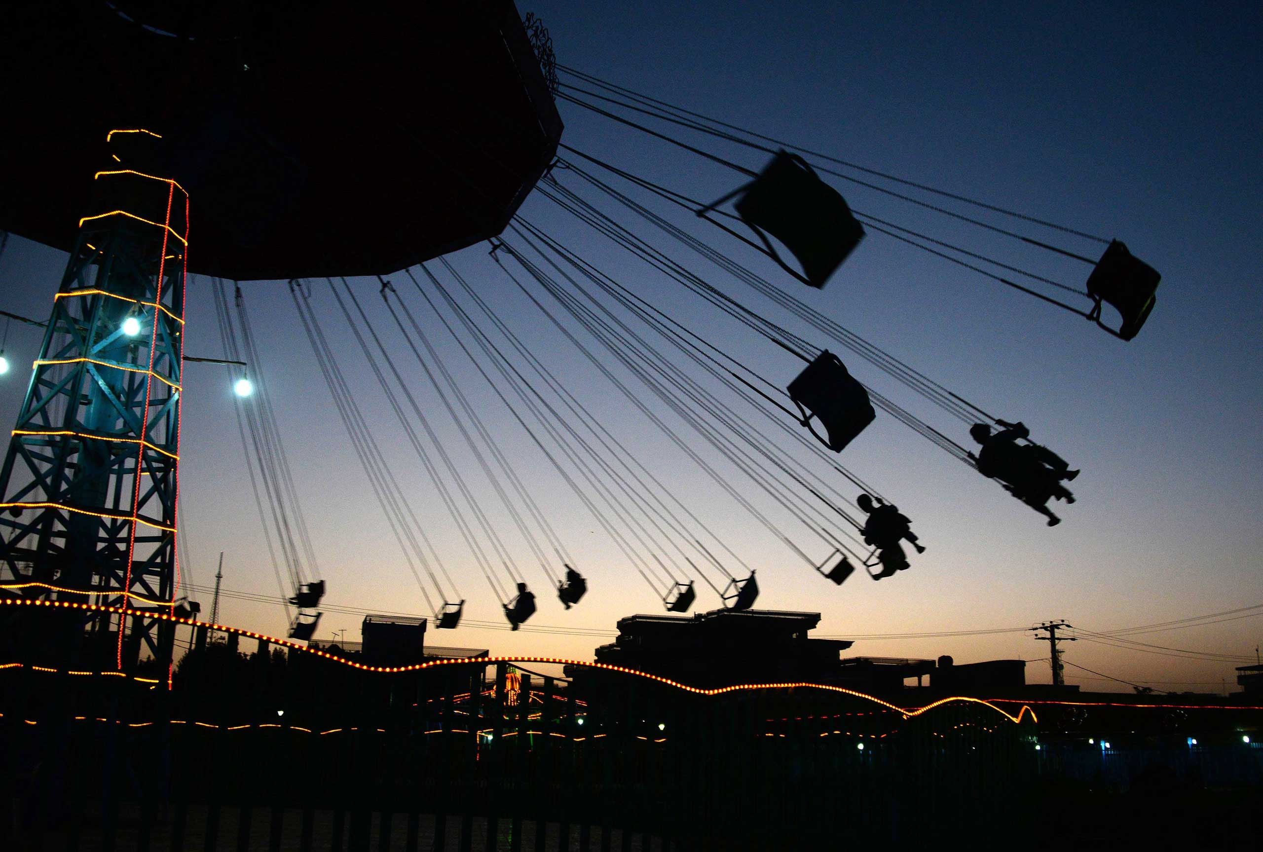 Afghan youth enjoy a ride on the swings at a park in Mazar-i- Sharif on Sept. 12, 2014.