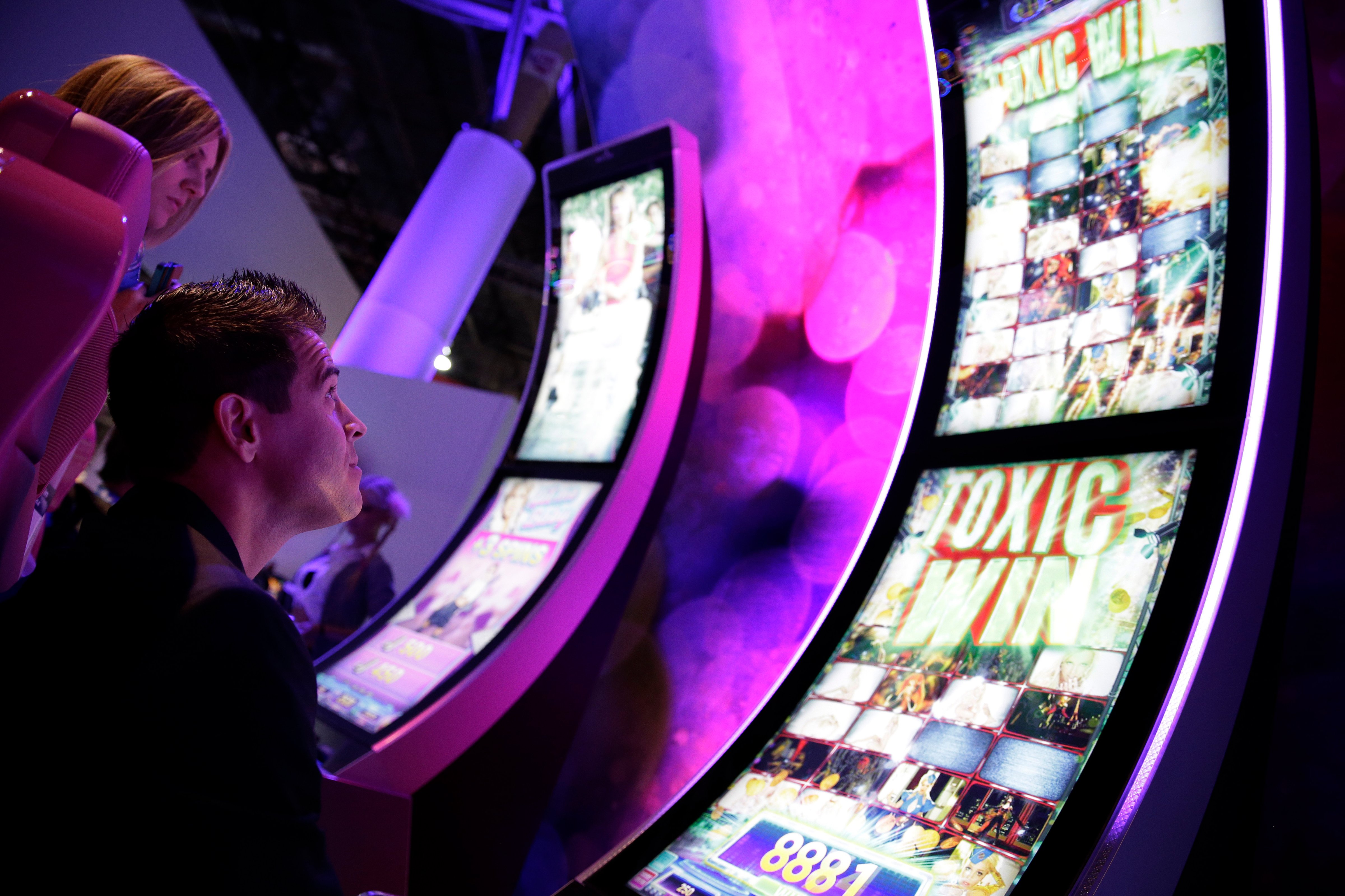 A man looks at a gambling machine at the Aristocrat booth during the Global Gaming Expo Tuesday, Sept. 30, 2014, in Las Vegas. (John Locher—AP)