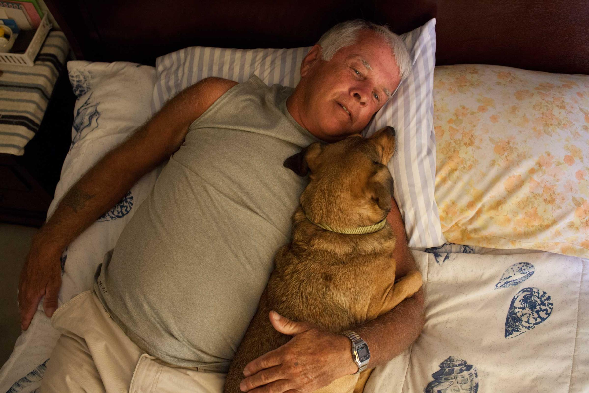Gene laying down with his dog Killer for a nap."Only a fool would truly trust anyone if you are a sex offender."