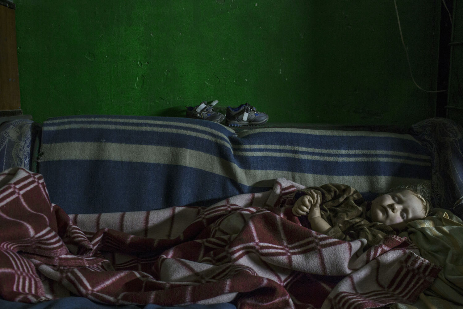 A young boy sleeps in an underground room at a college in Yasinovataya, near Donetsk.