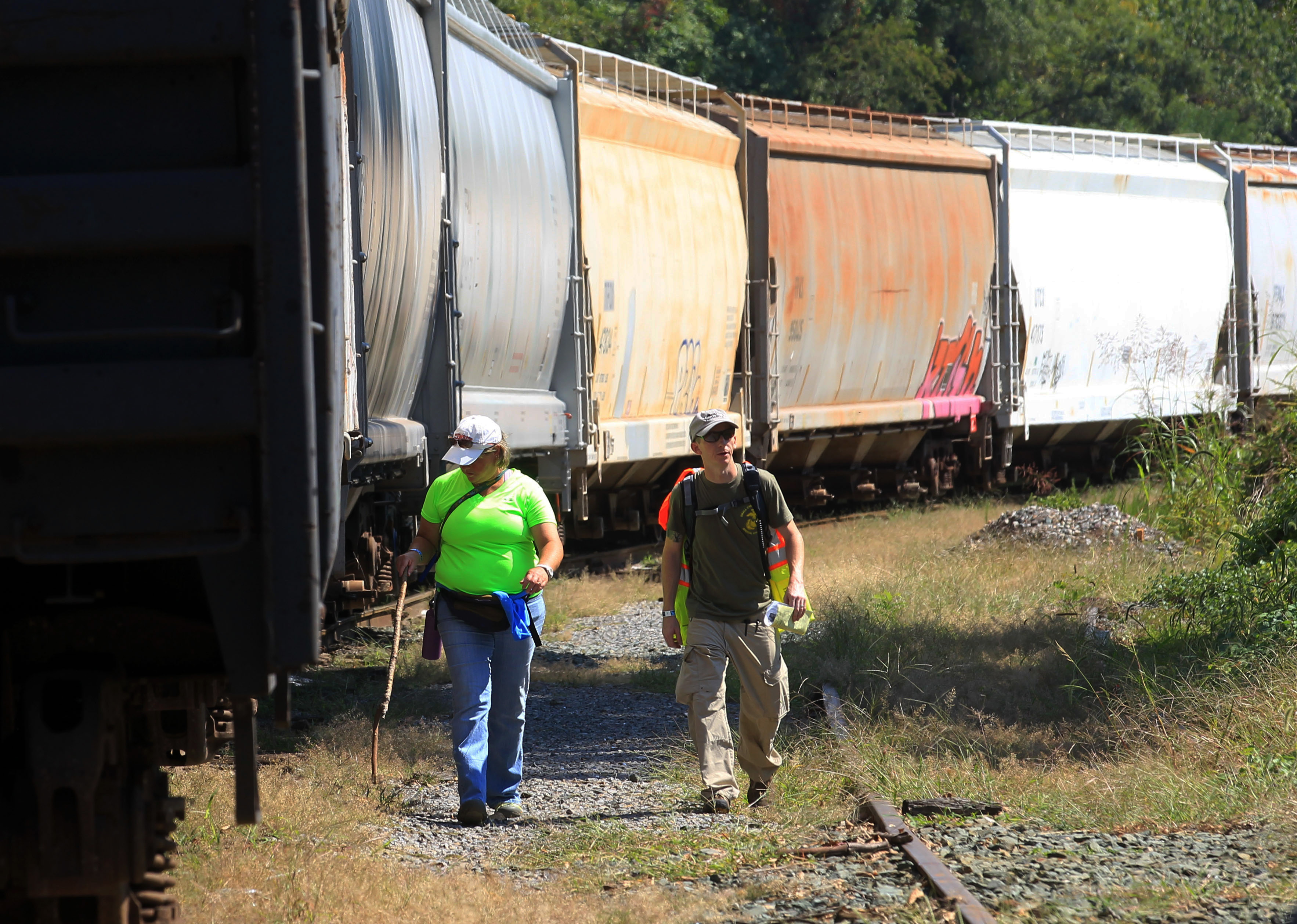 Volunteer Linda Cassell, left, walks with search team leader Brian Pace, as they search along the railroad tracks behind the Charlottesville Downtown Mall during a massive search effort by the community for missing University of Virginia student Hannah Graham, Sept. 20, 2014, in Charlottesville, Va. (Andrew Shurtleff—The Daily Progress/AP)