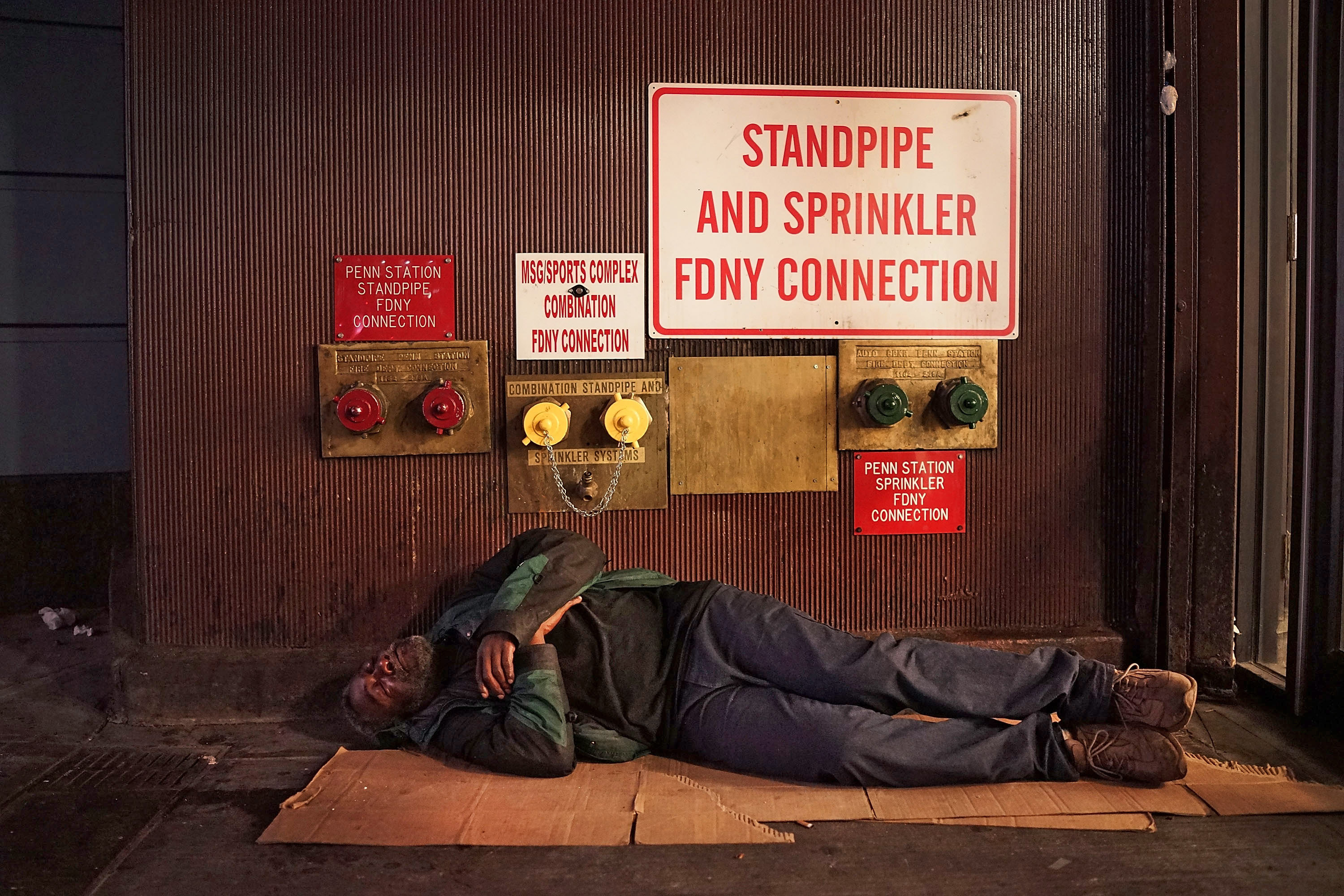 A homeless man sleeps on a Manhattan street on Aug. 22, 2014 in New York City. (Spencer Platt—Getty Images)
