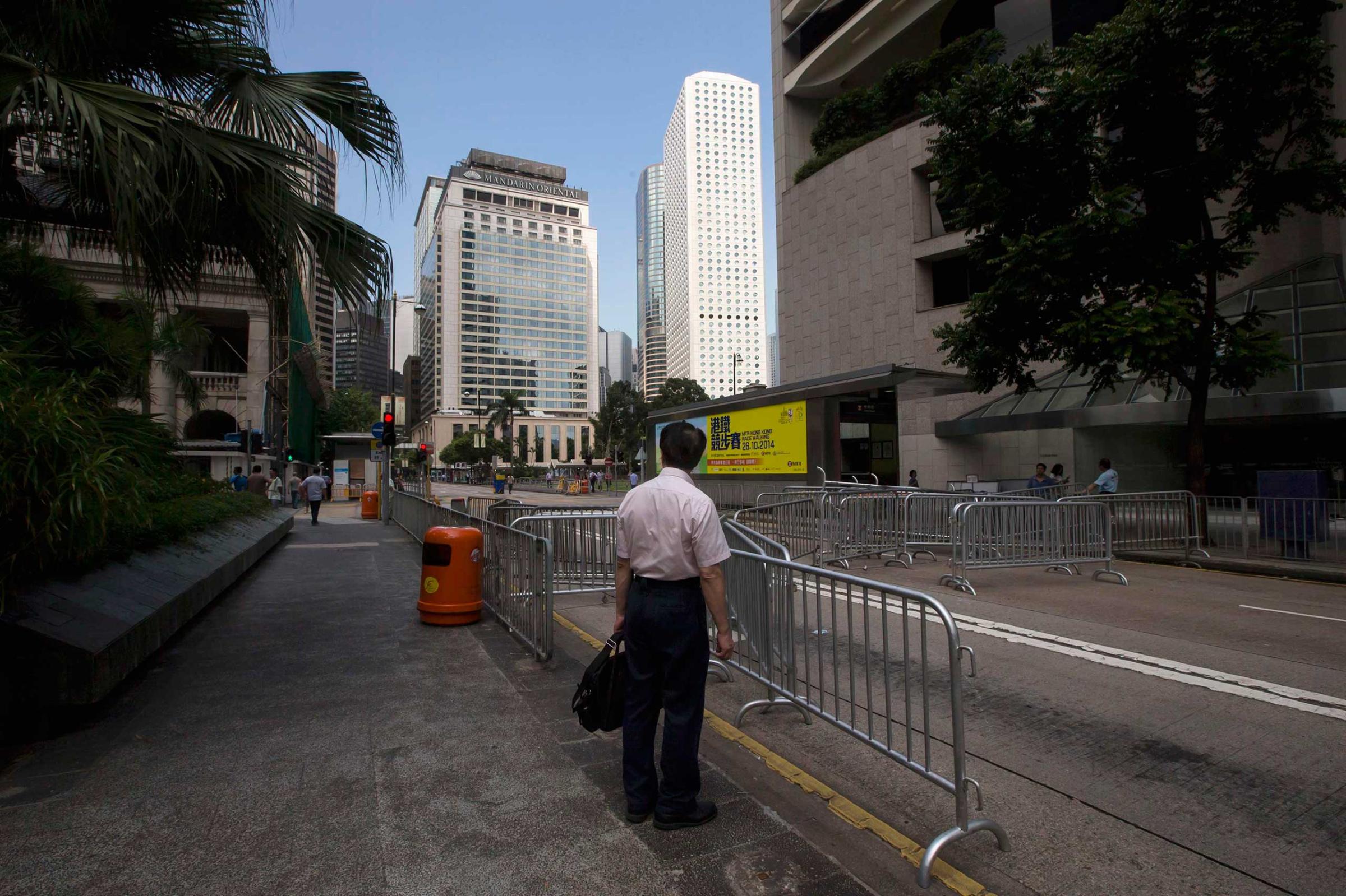 A businessman stands in front of a road block set up by protesters at the main street of the financial Central district in Hong Kong Sept. 29, 2014.