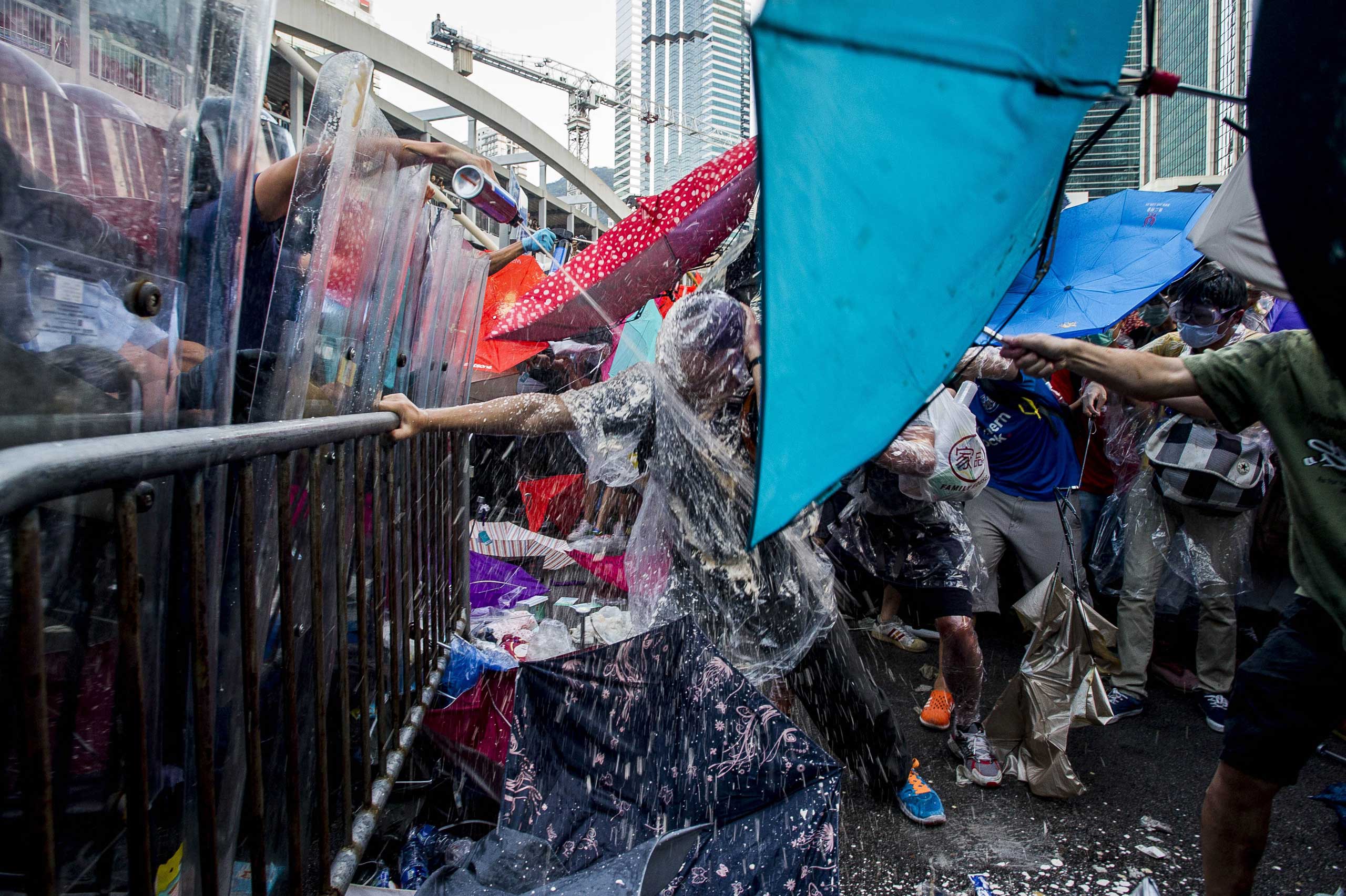 Pro-democracy demonstrators are sprayed with pepper spray during clashes with police officers during a rally near the Hong Kong government headquarters on Sept. 28, 2014.