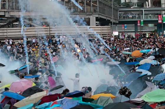 Riot police launch tear gas into the crowd as thousands of protesters surround the government headquarters in Hong Kong, Sept. 28, 2014.