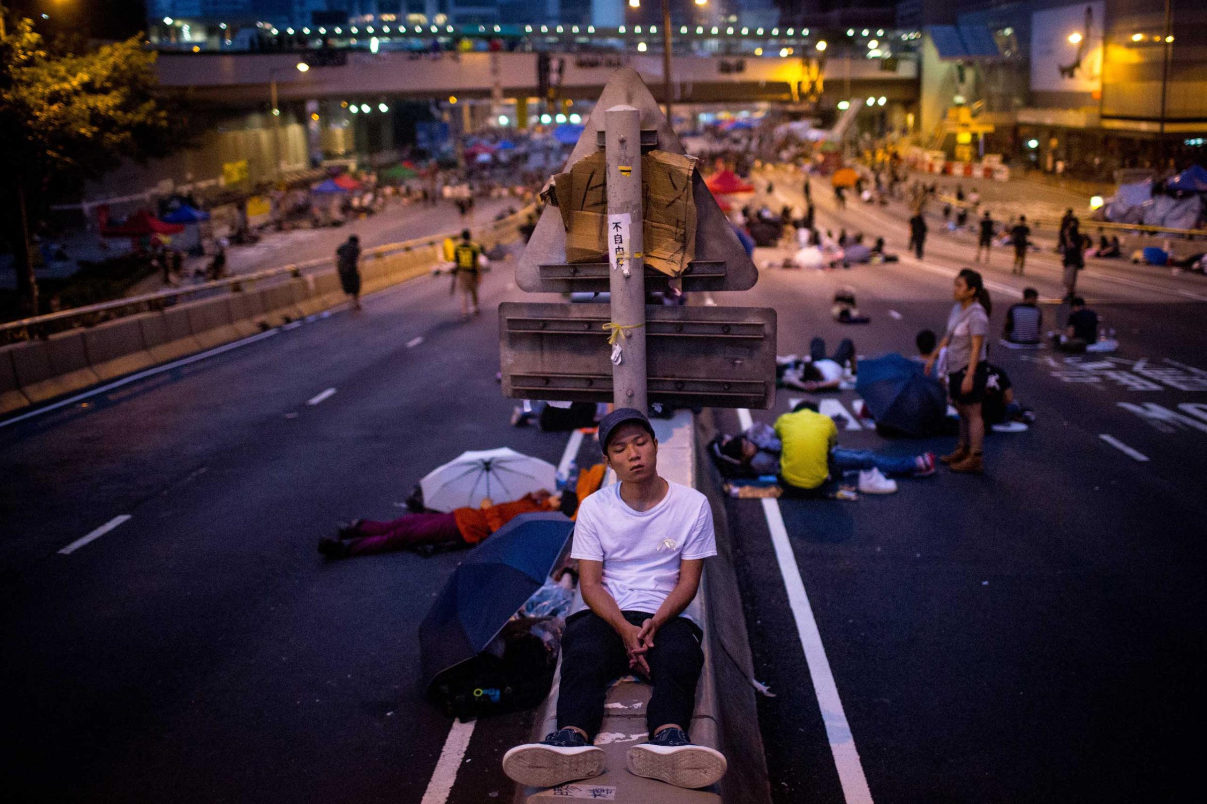 A pro-democracy protester sleeps on a concrete road divider on a street outside the Hong Kong Government Complex on Oct. 5, 2014 in Hong Kong.