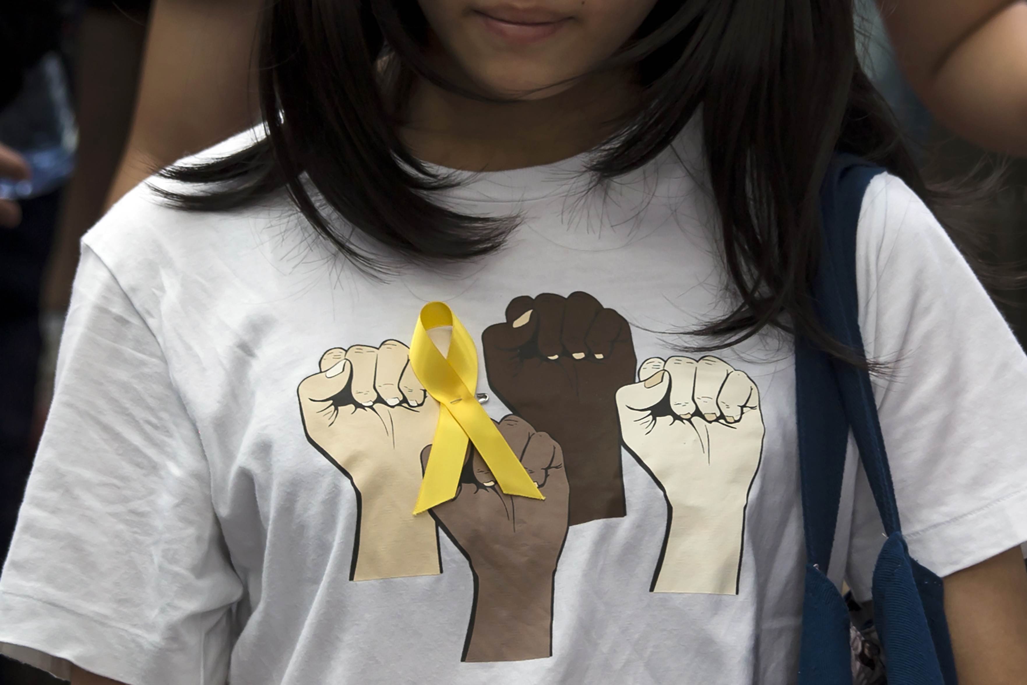 A secondary school student wears a yellow ribbon pinned to her T-shirt during a rally against Beijing's election framework for Hong Kong, outside the government headquarters in Hong Kong on Sept. 26, 2014. (Tyrone Siu—Reuters)