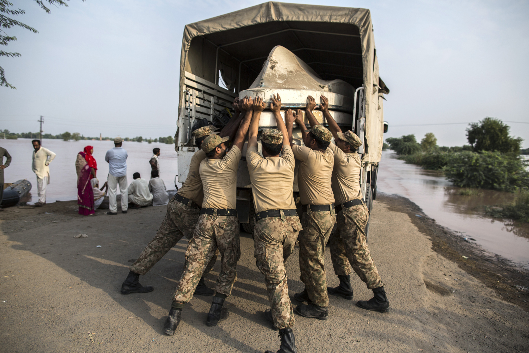 Army soldiers unload boats to be used for evacuating flood victims from their flooded houses following heavy rain in Jhang, Punjab province, Pakistan, Sept. 10, 2014.