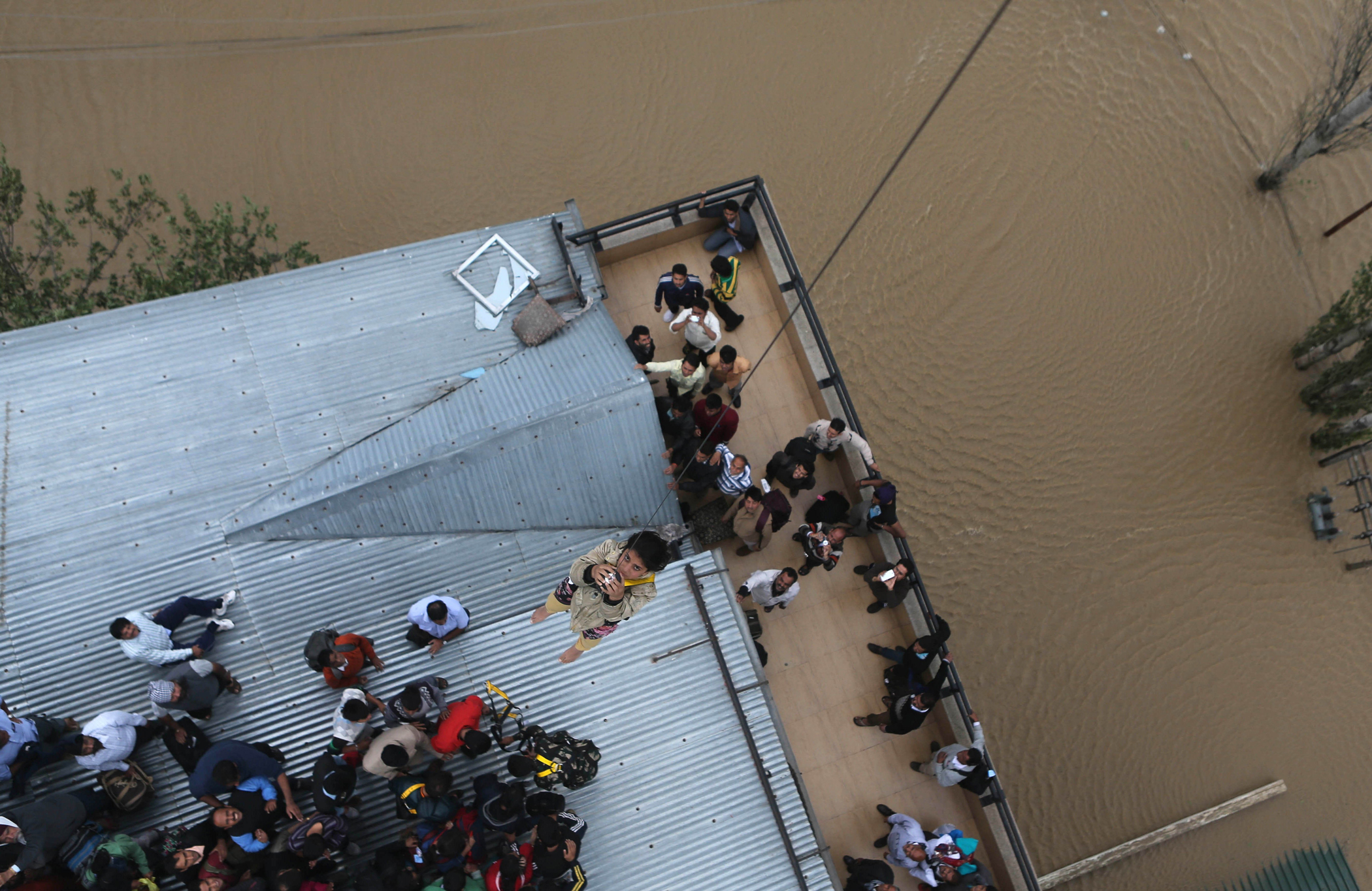 A Kashmiri woman is airlifted from the roof of a of a five-story hotel, four of which are submerged in floodwaters, in Srinagar, India, Sept. 9, 2014.