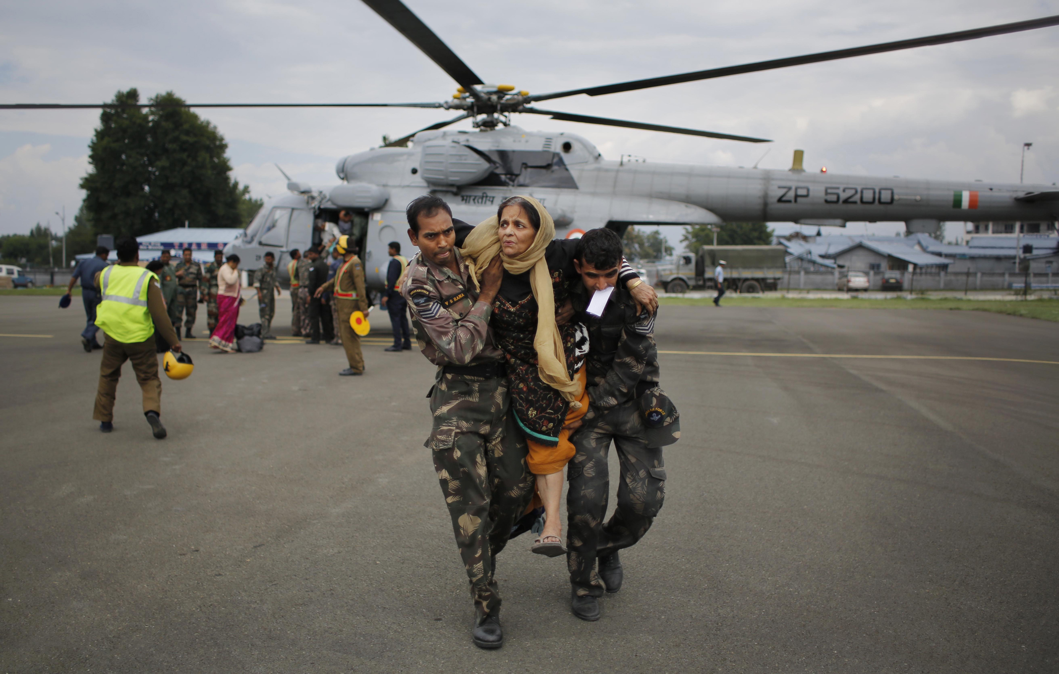 Indian soldiers carry a rescued flood victim at the Air Force Station in Srinagar, India, Sept. 9, 2014.
