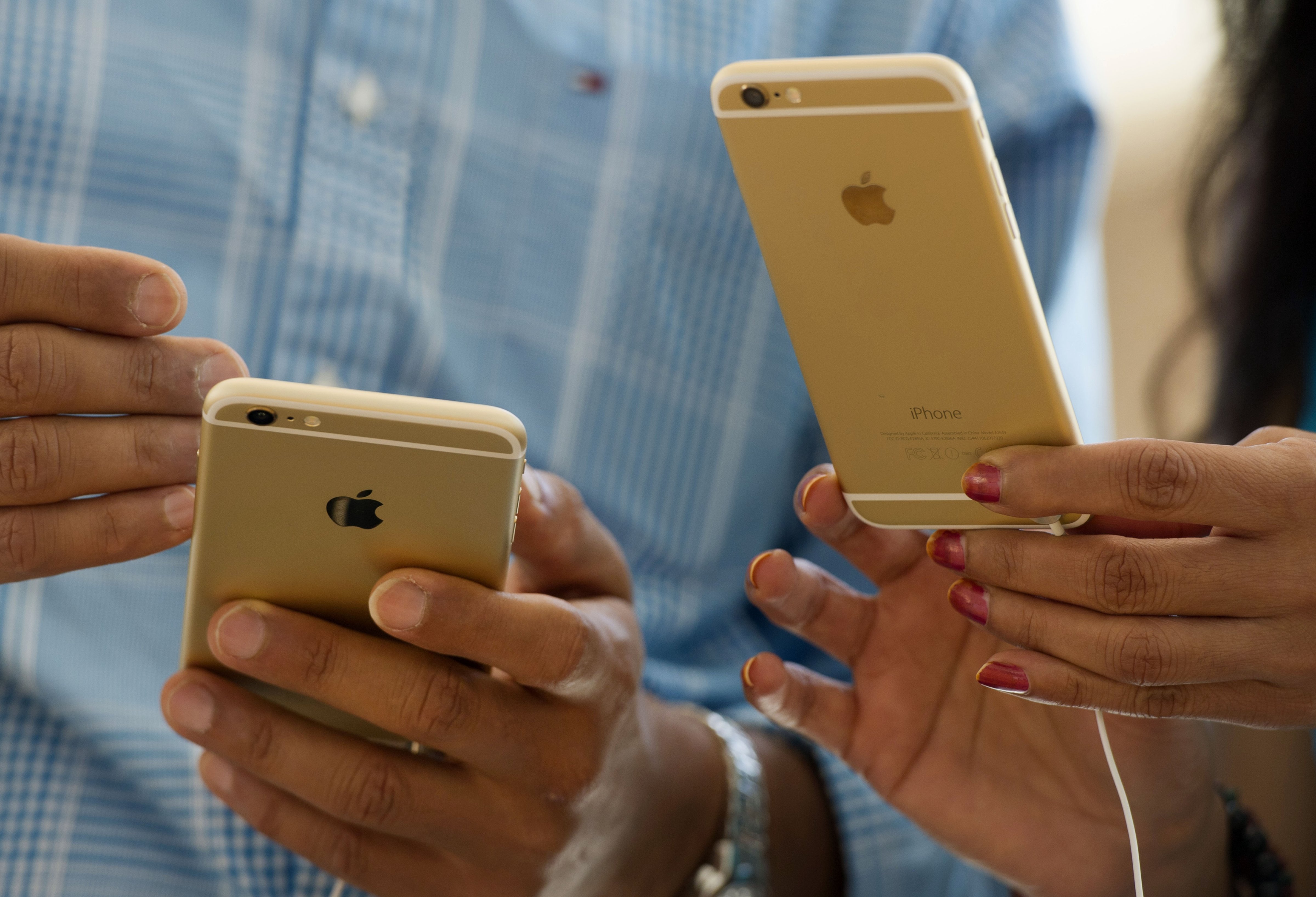 Customers compare an Apple Inc. iPhone 6, left, and iPhone 6 plus during the sales launch at an Apple store in Palo Alto, California, U.S., on Friday, Sept. 19, 2014. (Bloomberg&mdash;Bloomberg via Getty Images)