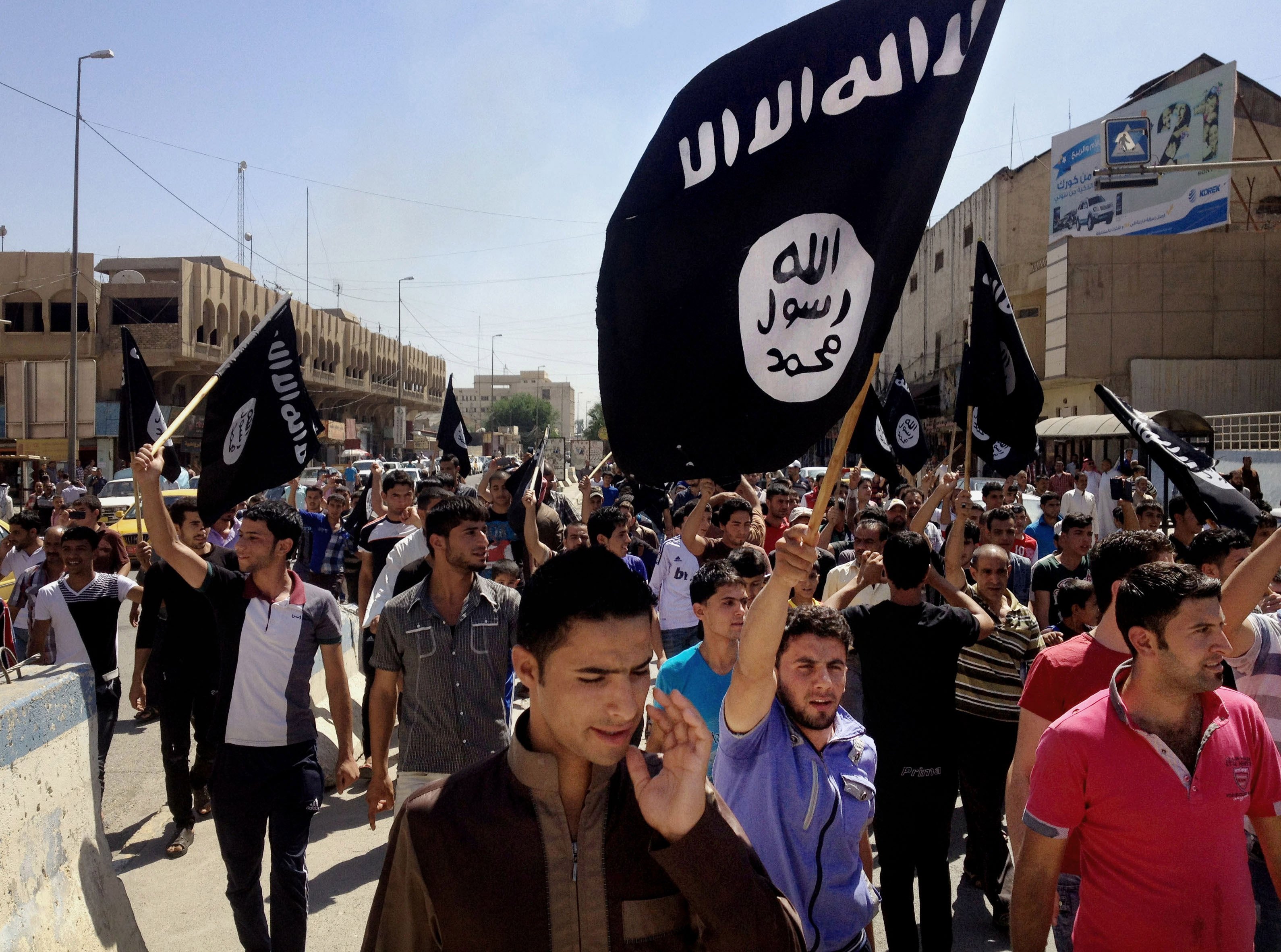 Demonstrators chant pro-Islamic State group slogans as they carry the group's flags in front of the provincial government headquarters in Mosul, Iraq on June 16, 2014. (AP)