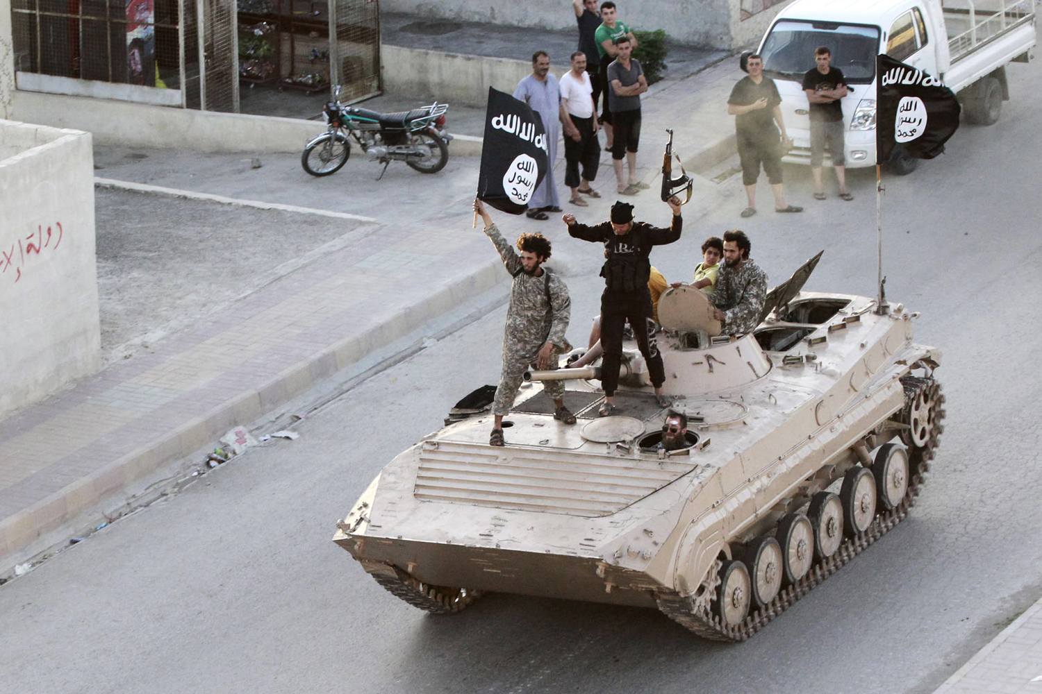 Militant Islamist fighters take part in a military parade along the streets of northern Raqqa province in Syria, June 30, 2014.