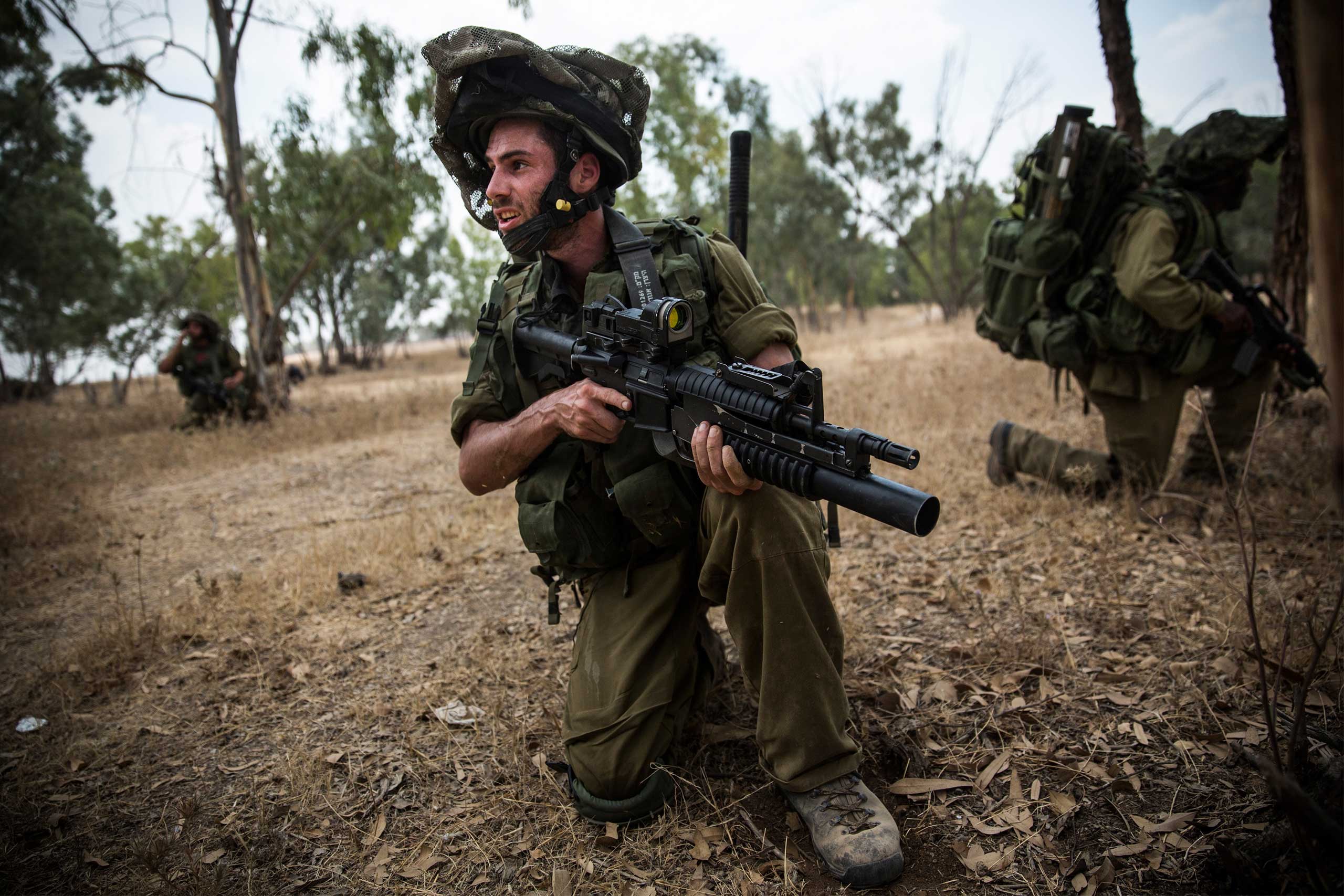 Israeli soldiers practice training missions close to the Israel-Gaza border as seen from near Sderot, Israel, July 22, 2014.