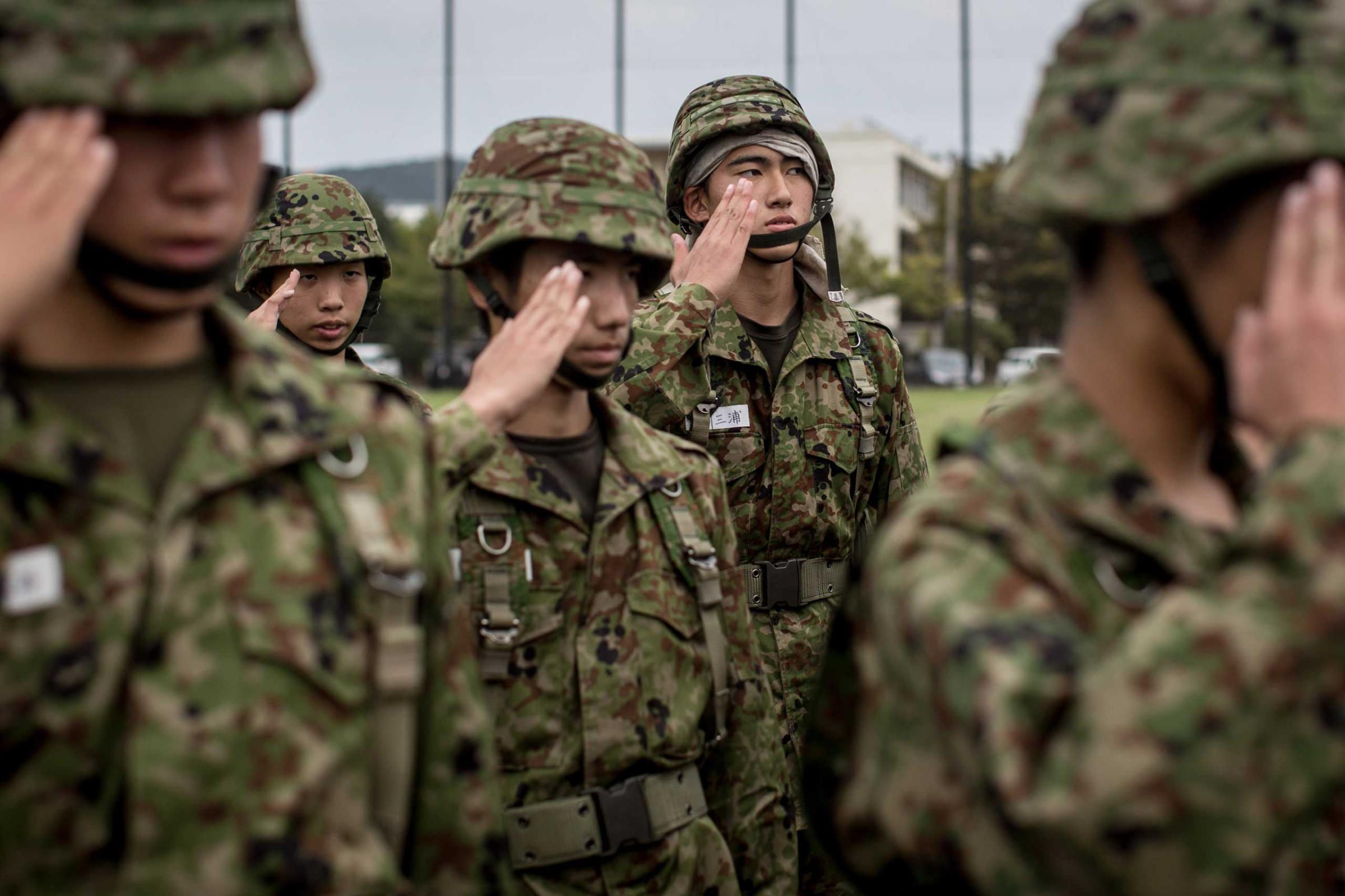 Students salute their teacher after finishing rifle training.
