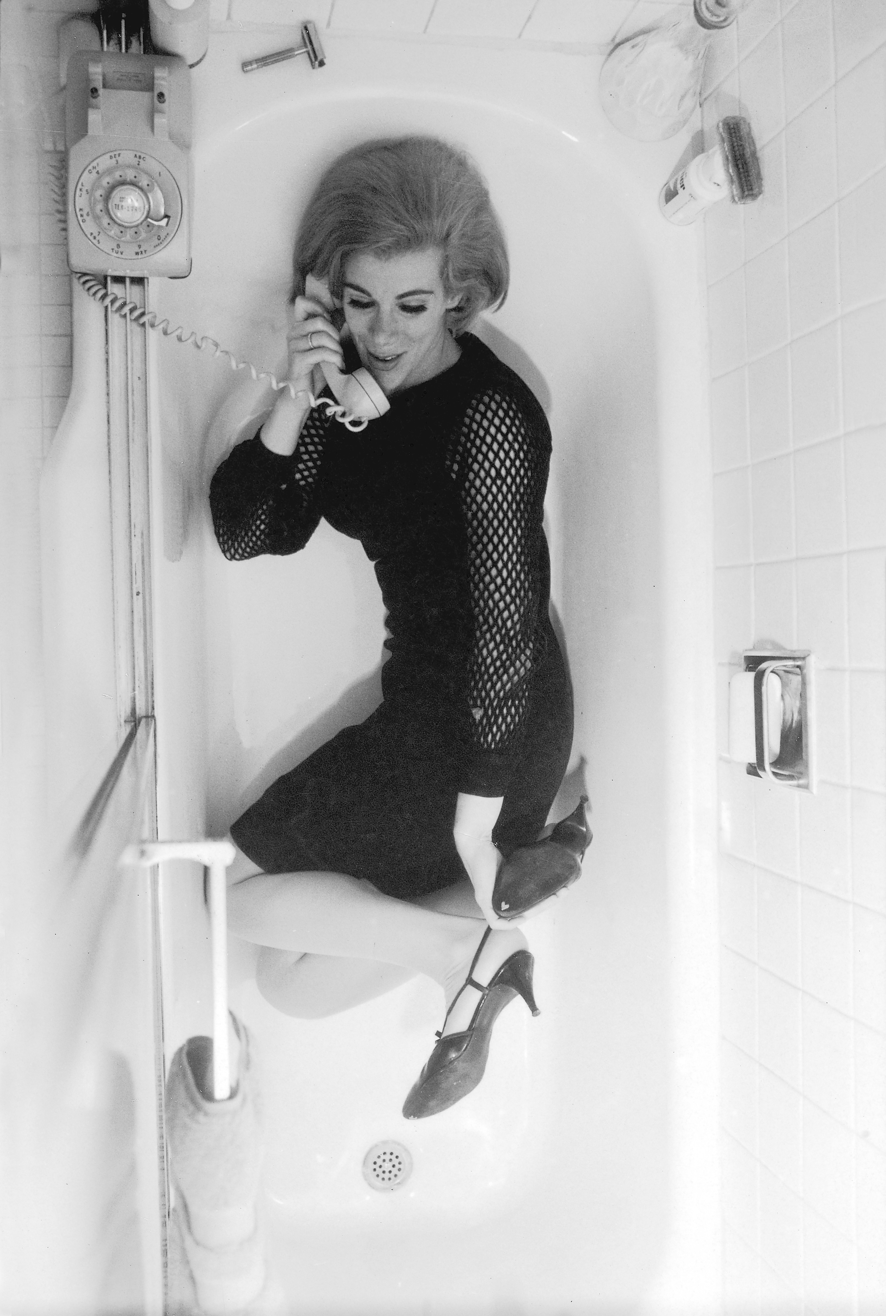 Comedienne Joan Rivers wearing black mesh dress and heels, while talking on the phone in a bathtub in New York City on March 1, 1966. (Truman Moore—The TIME &amp; LIFE Picture Collection/Getty Images)
