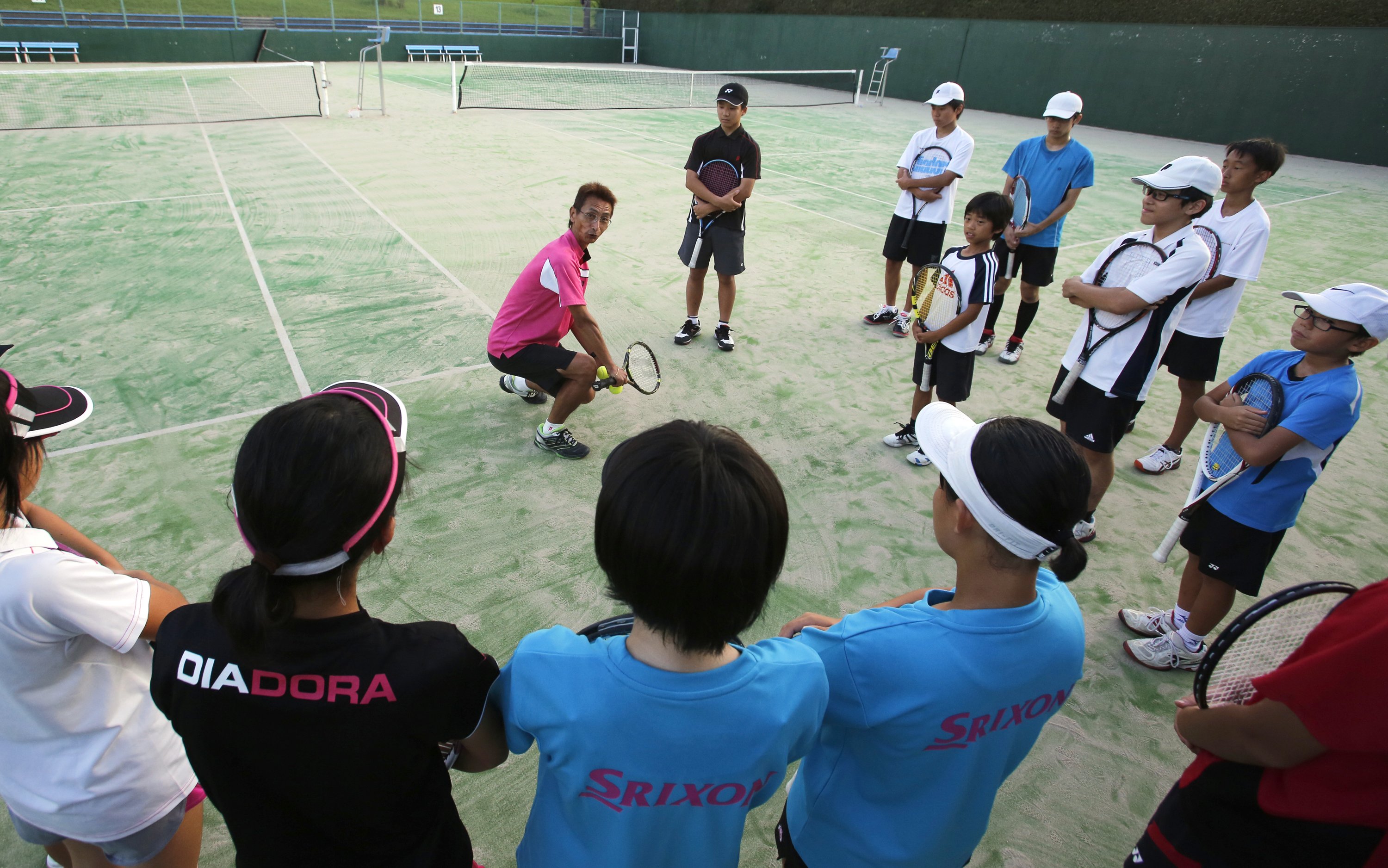 Green Tennis Garden coach Masaki Kashiwai teaches his students during lessons in the hometown of Japanese tennis player Kei Nishikori, Matsue, Japan on Sept. 8, 2014.