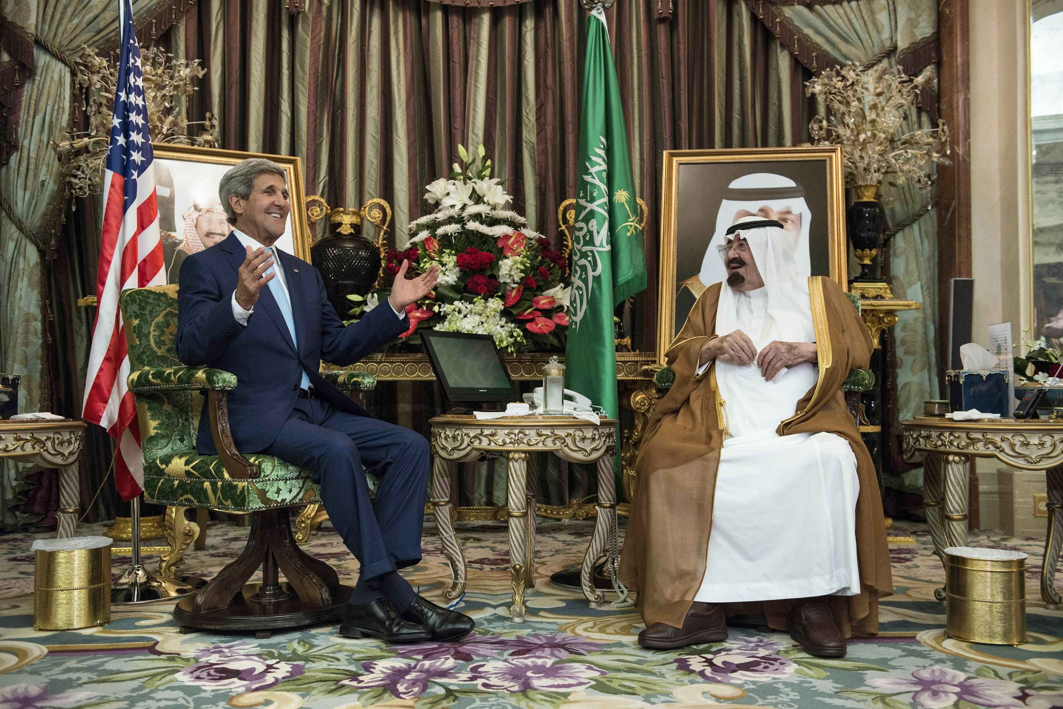 Saudi King Abdullah listens to U.S. Secretary of State Kerry before a meeting at the Royal Palace in Jeddah