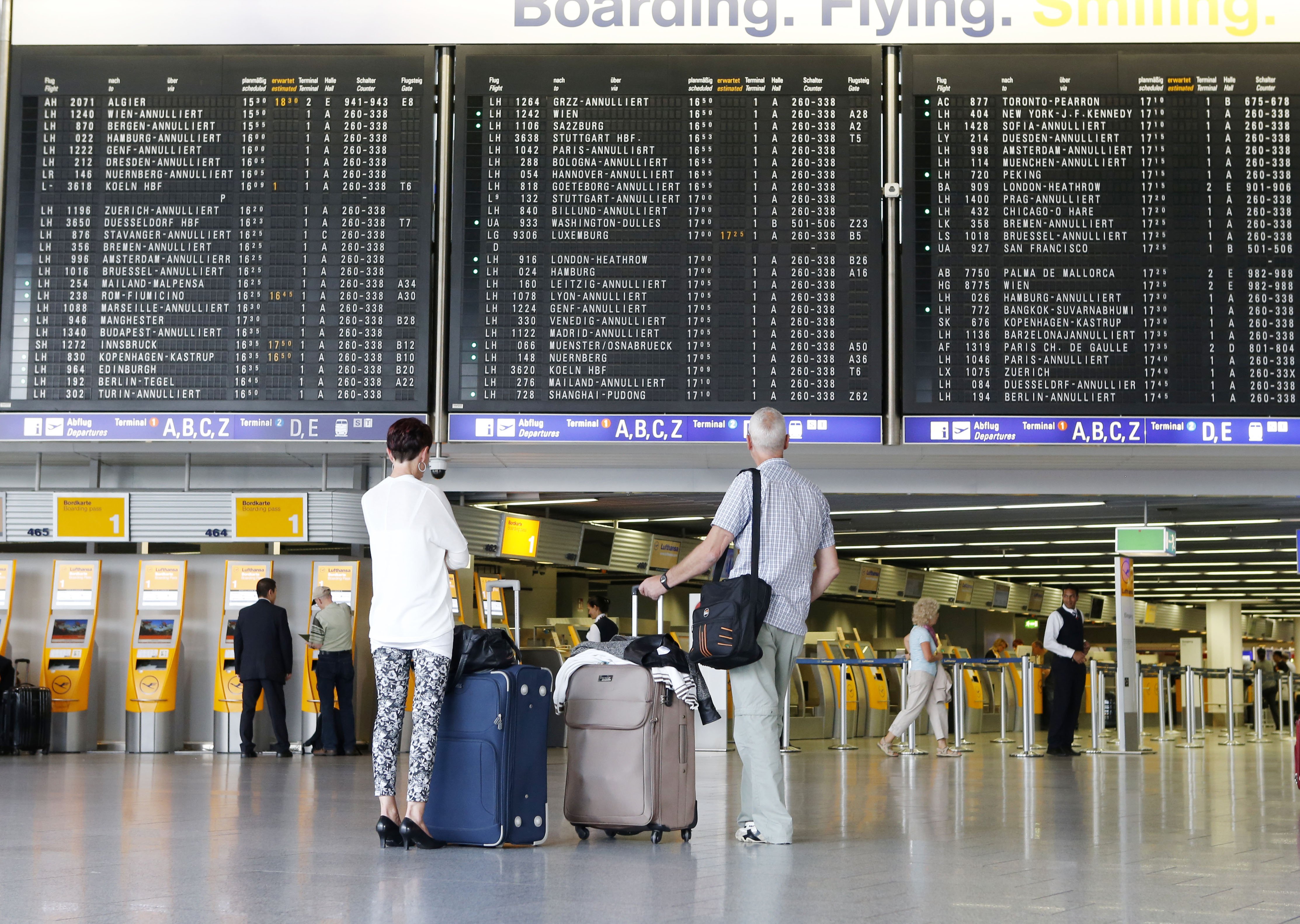 Passengers watch the flight board in a terminal at the airport just before pilots of Lufthansa went on a six hours warning strike in Frankfurt, Germany, Sept.5, 2014. (Michael Probst—AP)