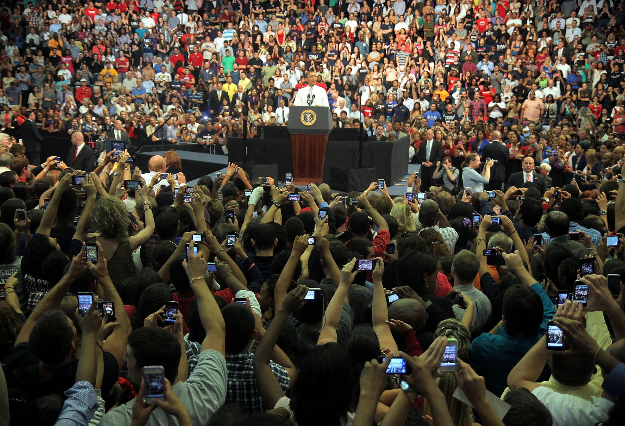 Audience members take pictures of President Barack Obama at Florida Atlantic University on April 10 in Boca Raton, Florida.