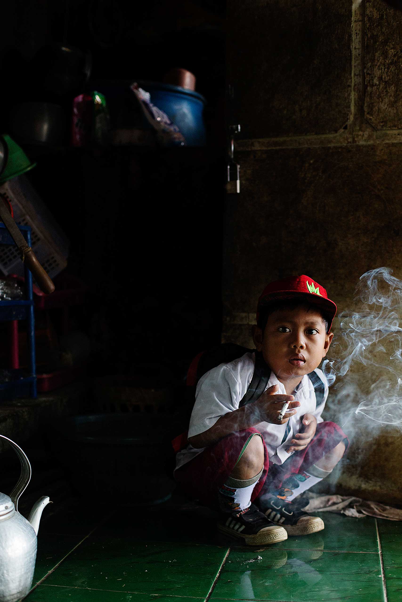 Dihan Muhamad has his first cigarette at 7AM at his home before he attends his first grade class in his village near the town of Garut, Indonesia on February 10, 2014.