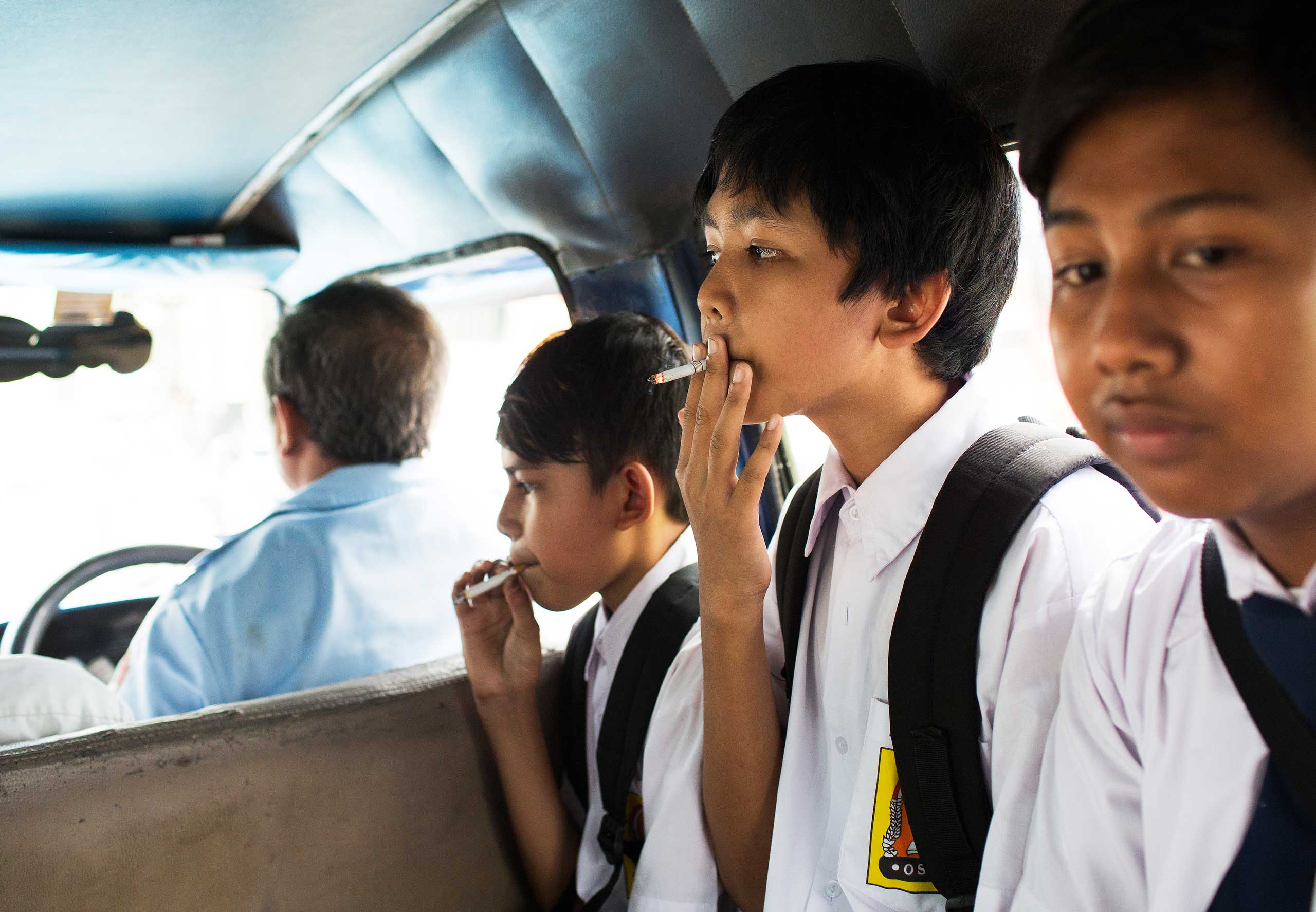 Children smoke on a public bus home from school on February 12, 2014 in Jakarta, Indonesia. Although there are smoking regulations in public places there is a lack of enforcement.
