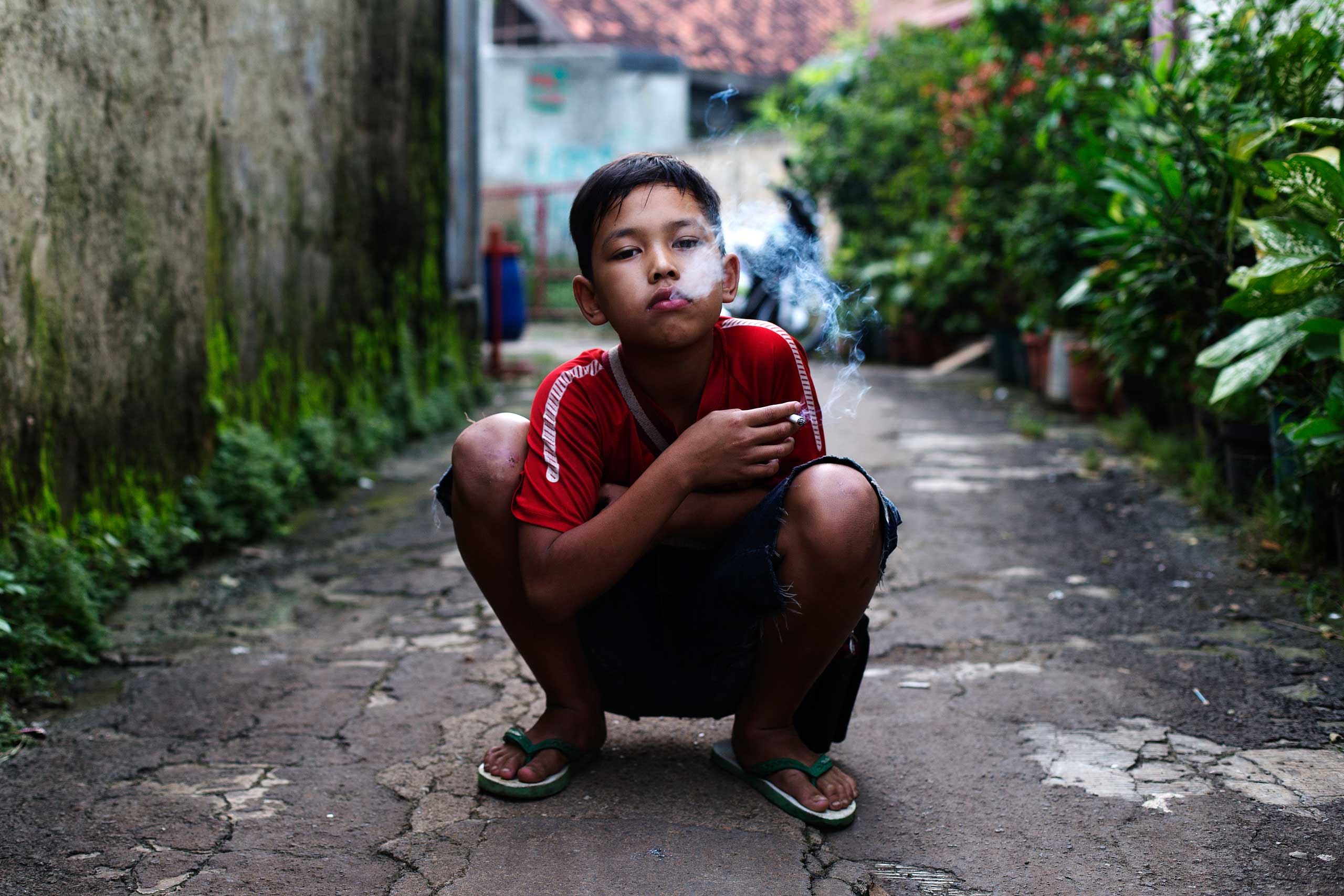 Rian, who smokes occasionally, poses for a photo as he smokes a cigarette in east Jakarta, Indonesia on February 12, 2014.