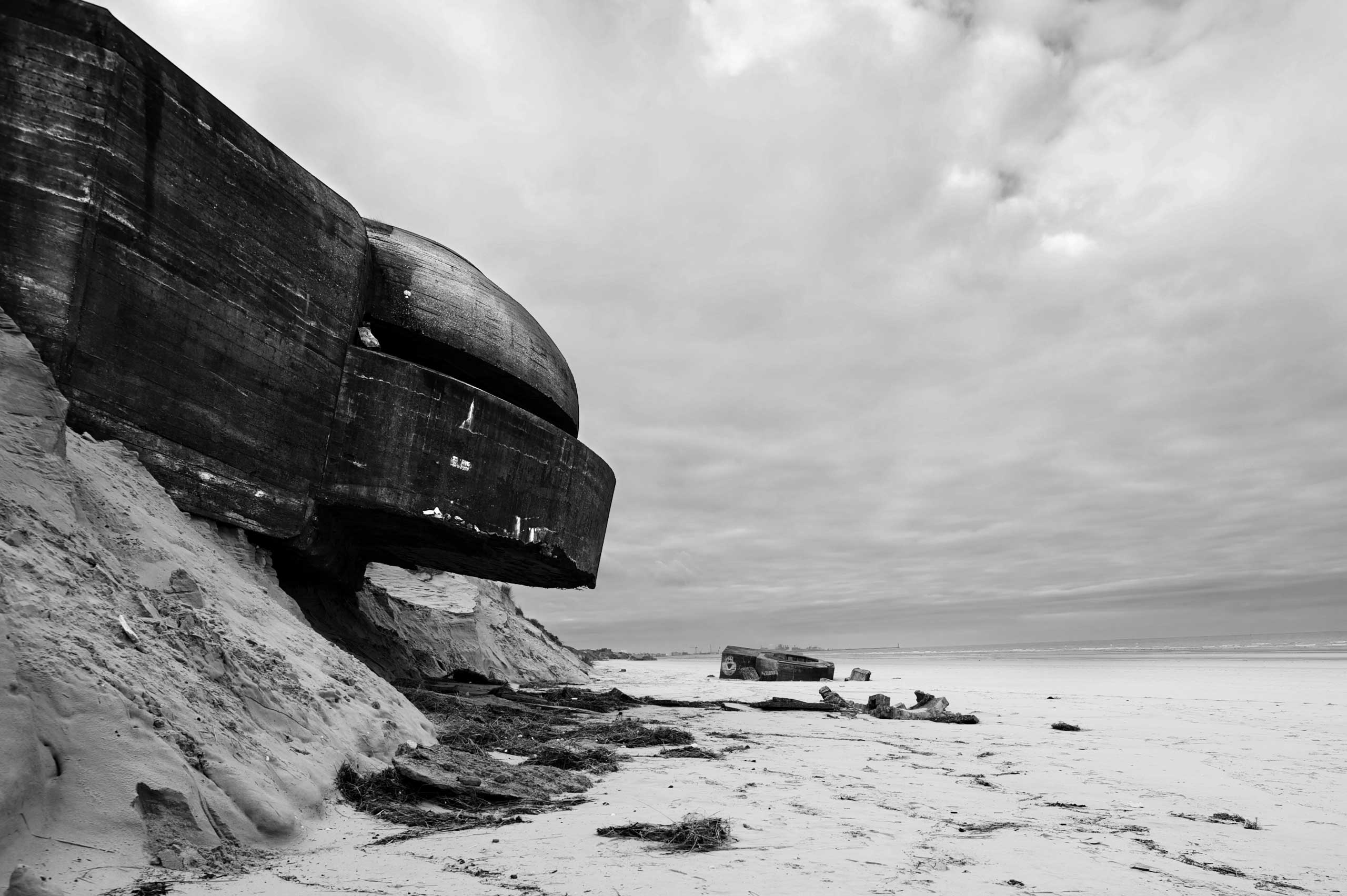 A concrete bunker used by the German Army in WWII sits precariously on top of an eroding sea front in France along the route of the Atlantic Wall (Atlantikwall in German).