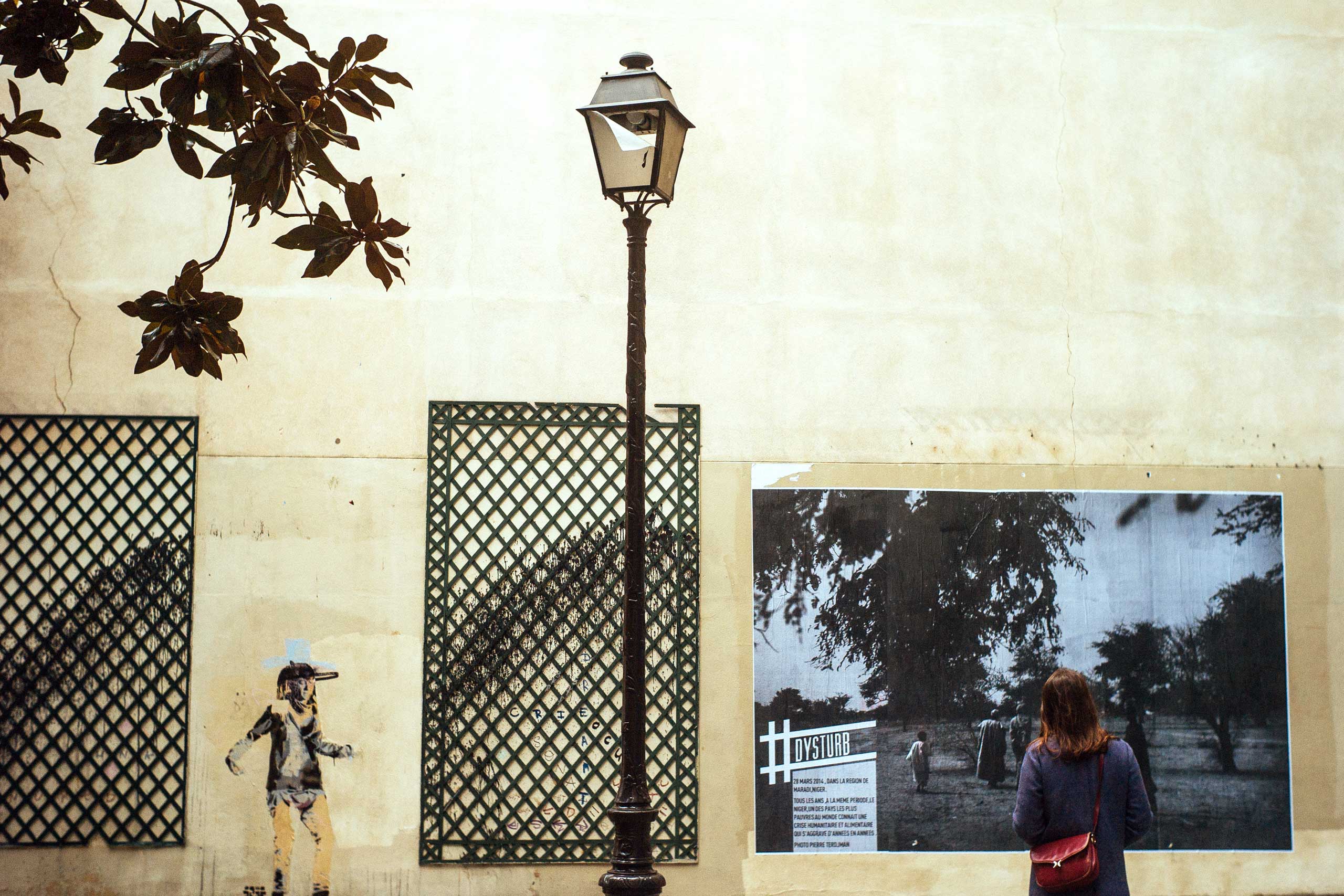 A woman stands in front of one of Pierre Terdjman's photographs in Paris.