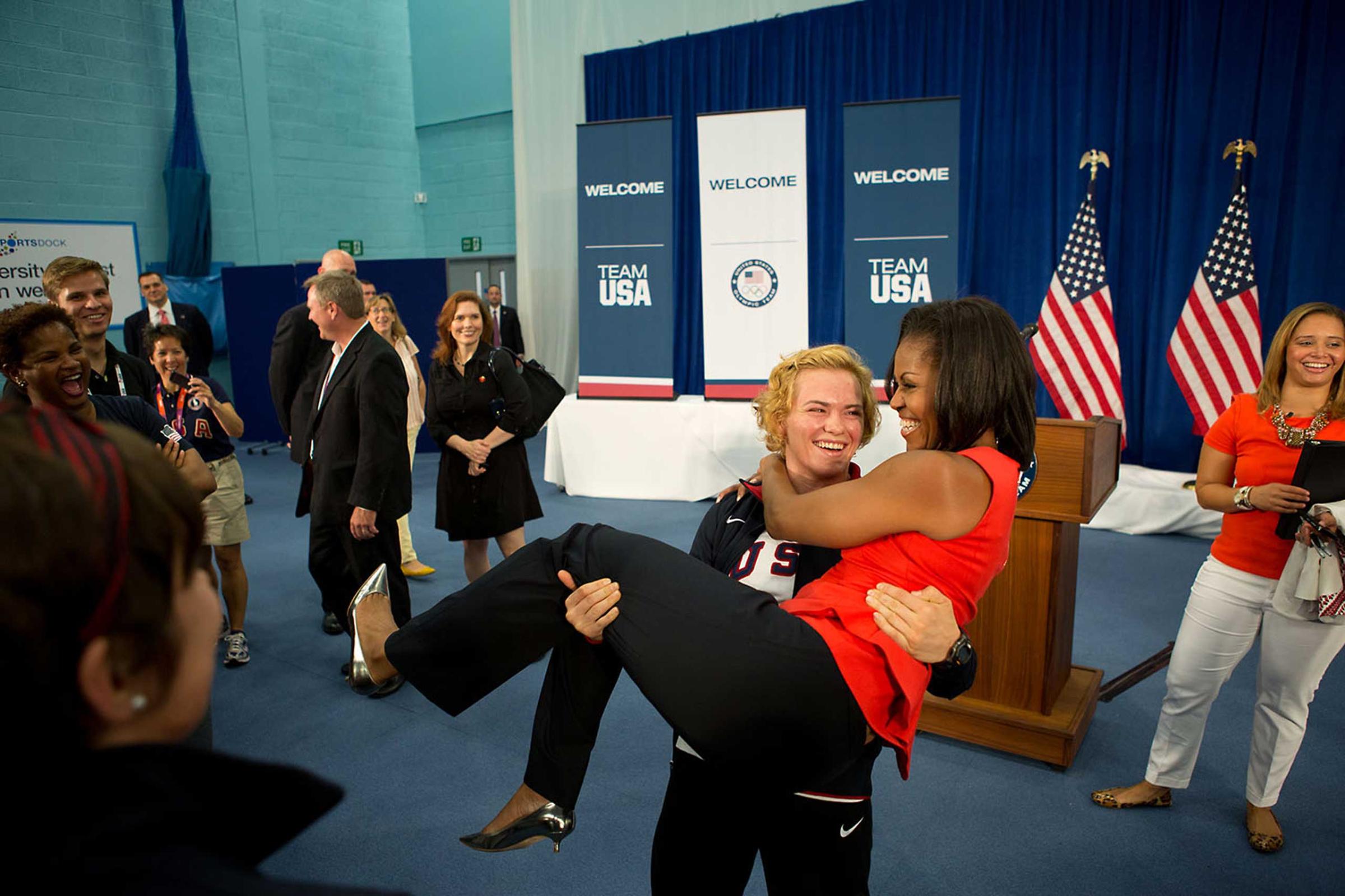 U.S. Olympic wrestler Elena Pirozhkova picks up the First Lady during a greet with Team USA Olympic athletes competing in the 2012 Summer Olympic Games, at the U.S. Olympic Training Facility at the University of East London in London, England, July 27, 2012.