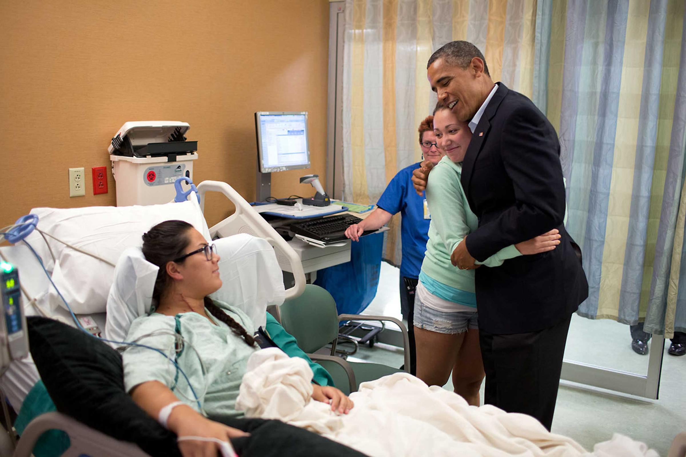 President Obama hugs Stephanie Davies while visiting shooting victim Allie Young at the University of Colorado Hospital in Aurora, Colo., July 22, 2012. Davies helped keep Young alive after her friend was wounded at the movie theater in Aurora. The President traveled to Colorado to visit with patients and family members affected by the shootings.