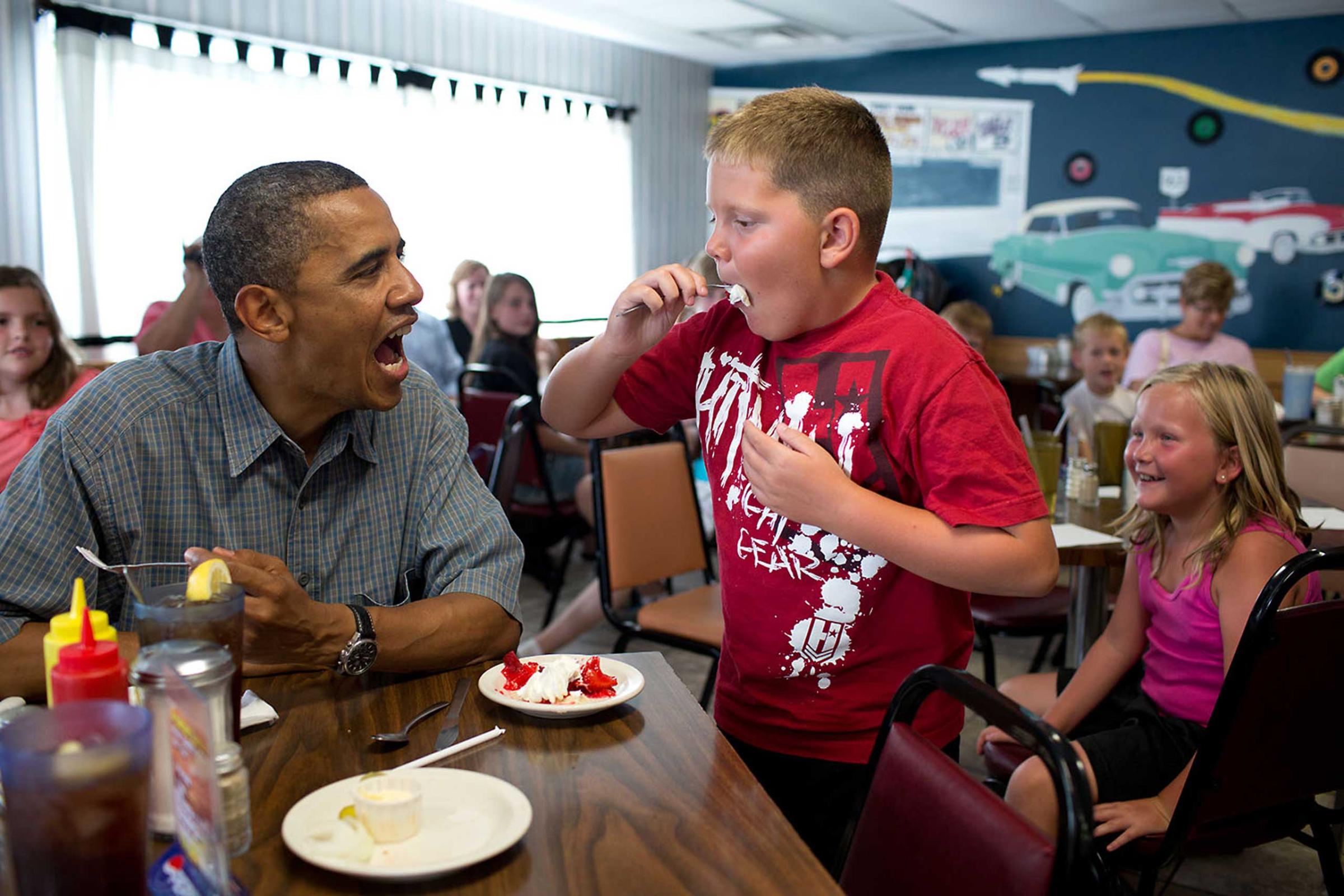 President Obama shares a piece of strawberry pie with a young patron at Kozy Corners, a local diner in Oak Harbor, Ohio, July 5, 2012.