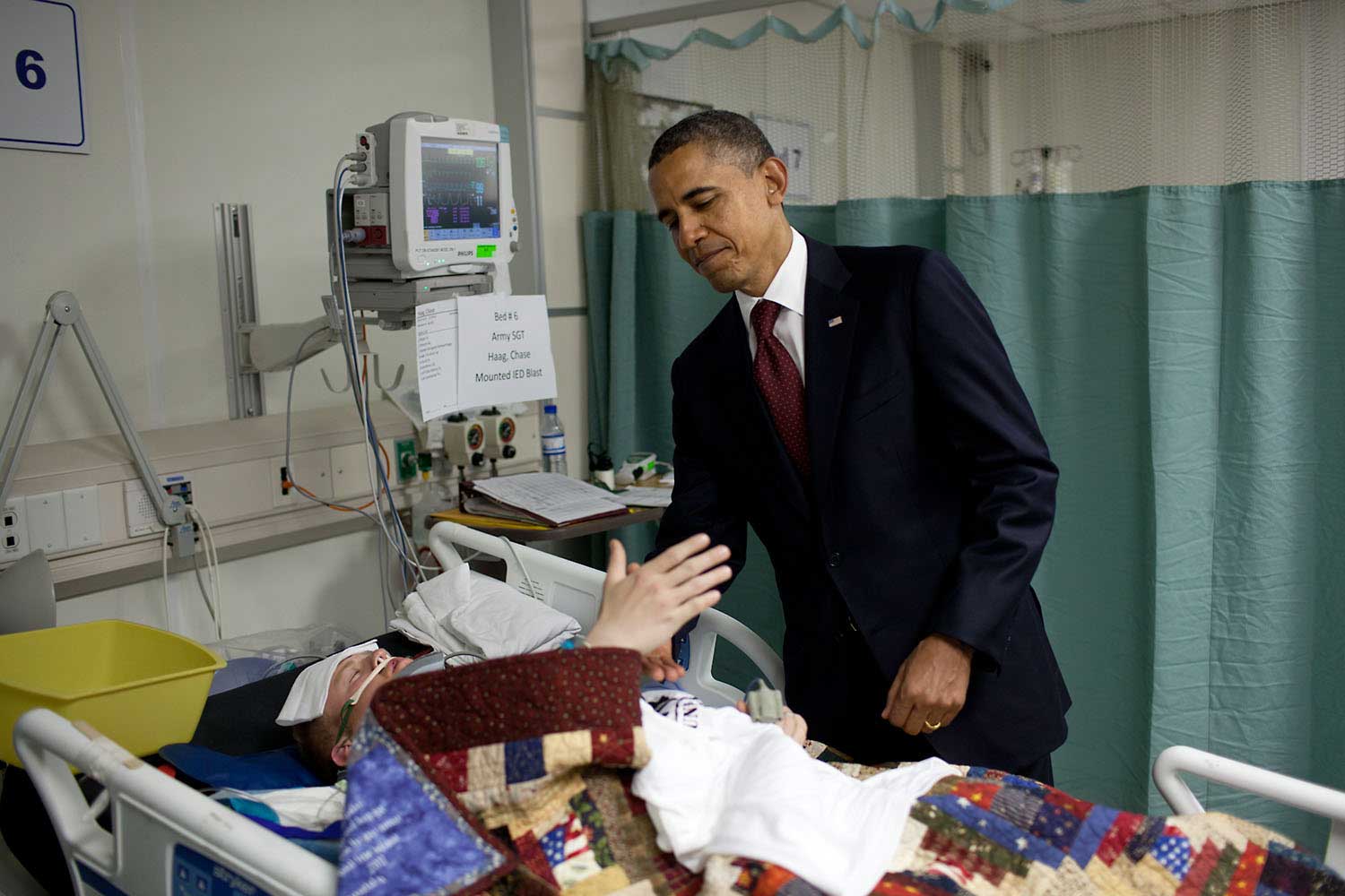 "This was one of the most poignant moments of the President's first term. He was visiting wounded warriors in the intensive care unit ICU at Bagram Air Field, Afghanistan, May 1, 2012. He had just presented a Purple Heart to Sgt. Chase Haag, who had been injured by an IED just hours before. Sgt. Haag was covered with a blanket and it was difficult to see how badly he was injured. He was also seemingly unconscious so the President whispered in his ear so not to wake him. Just then, there was a rustling under the blanket and Sgt. Haag, eyes still closed, reached his hand out to shake hands with the President."