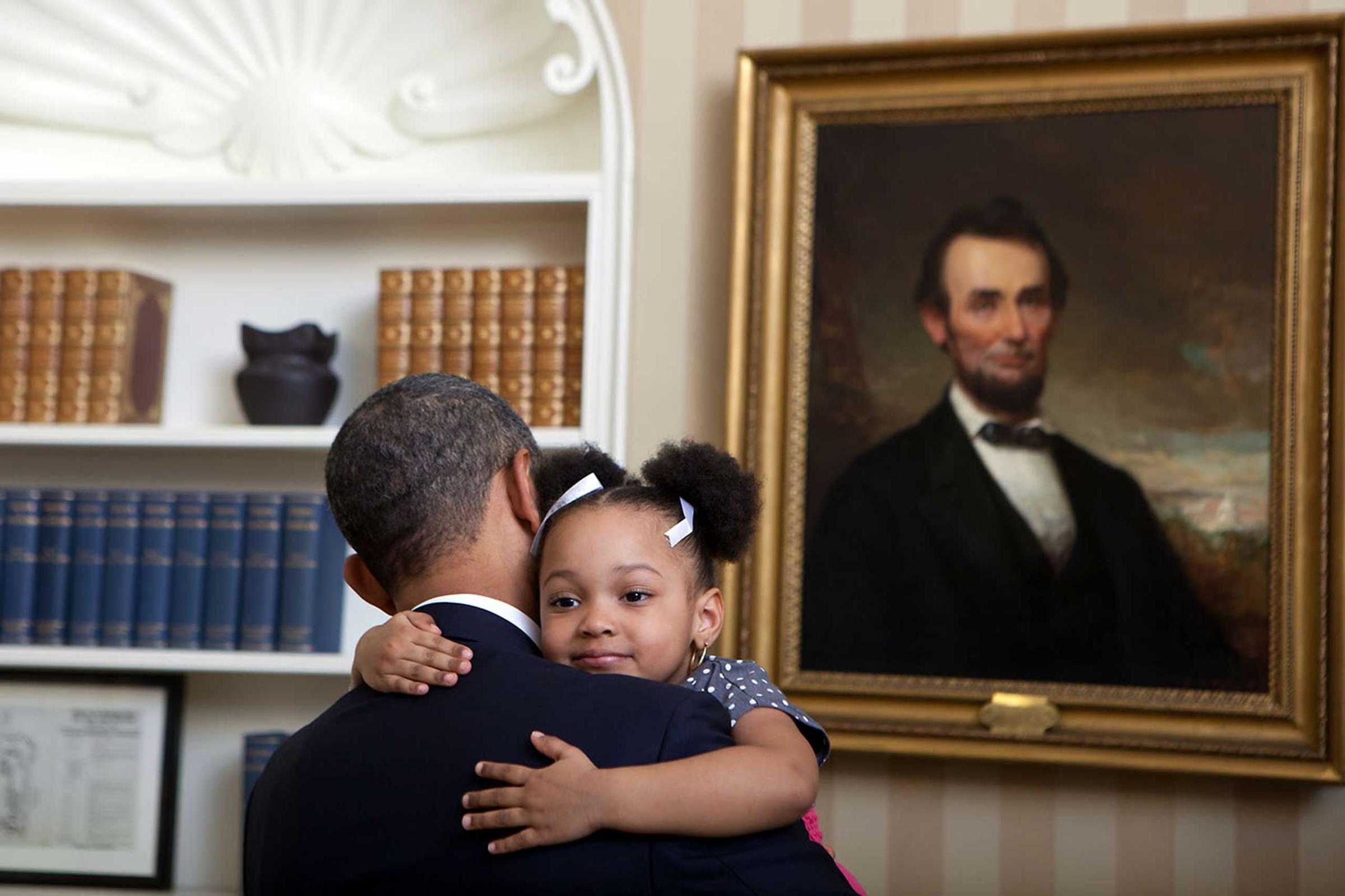 President Obama greets the daughter of national security staffer during a departure photo in the Oval Office, Feb. 1, 2012.