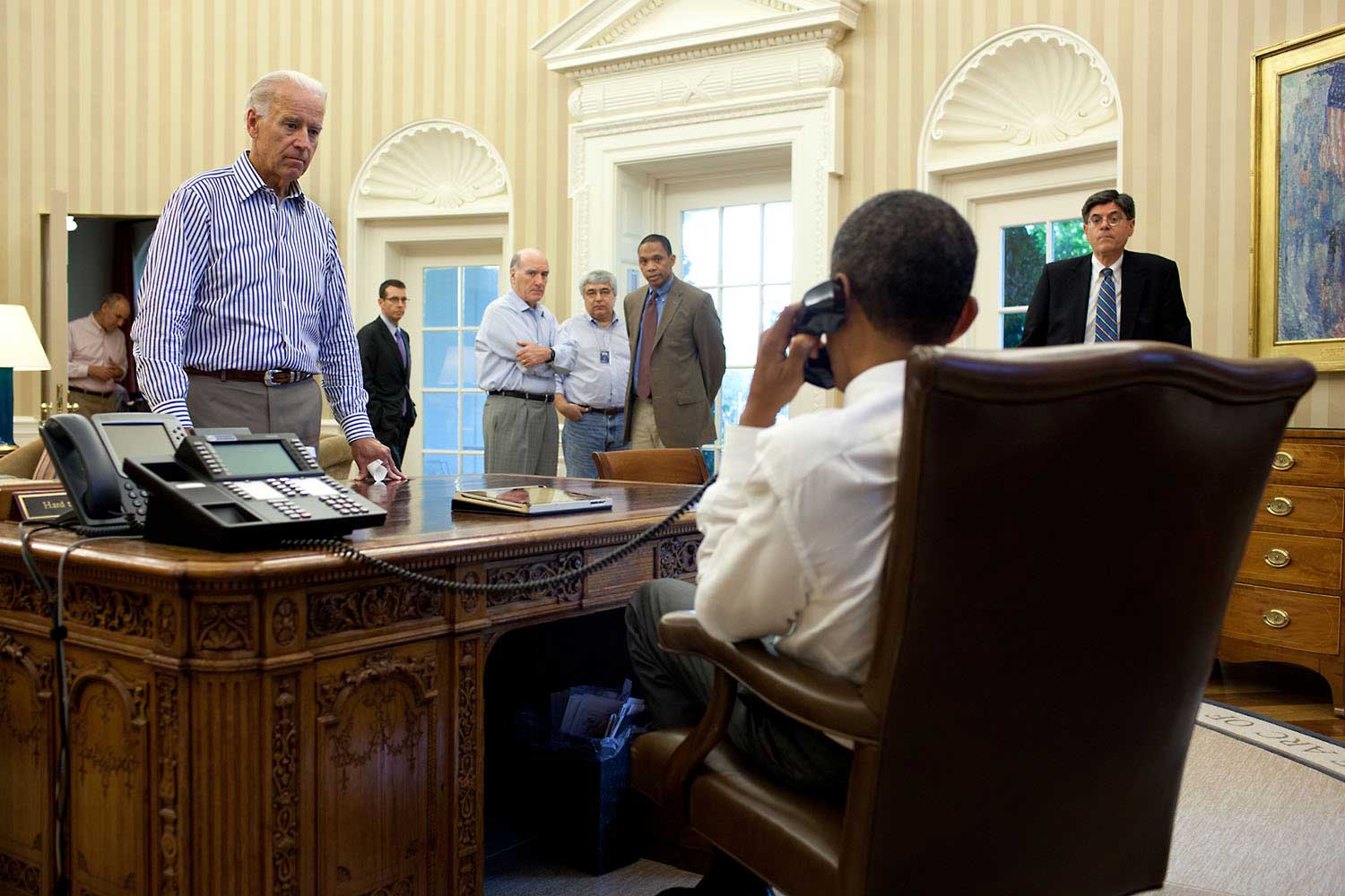 The Vice President and other staff watch and listen as the President talks on the phone in the Oval Office with Senate Majority Leader Harry Reid during the debt limit and deficit discussions, July 31, 2011.