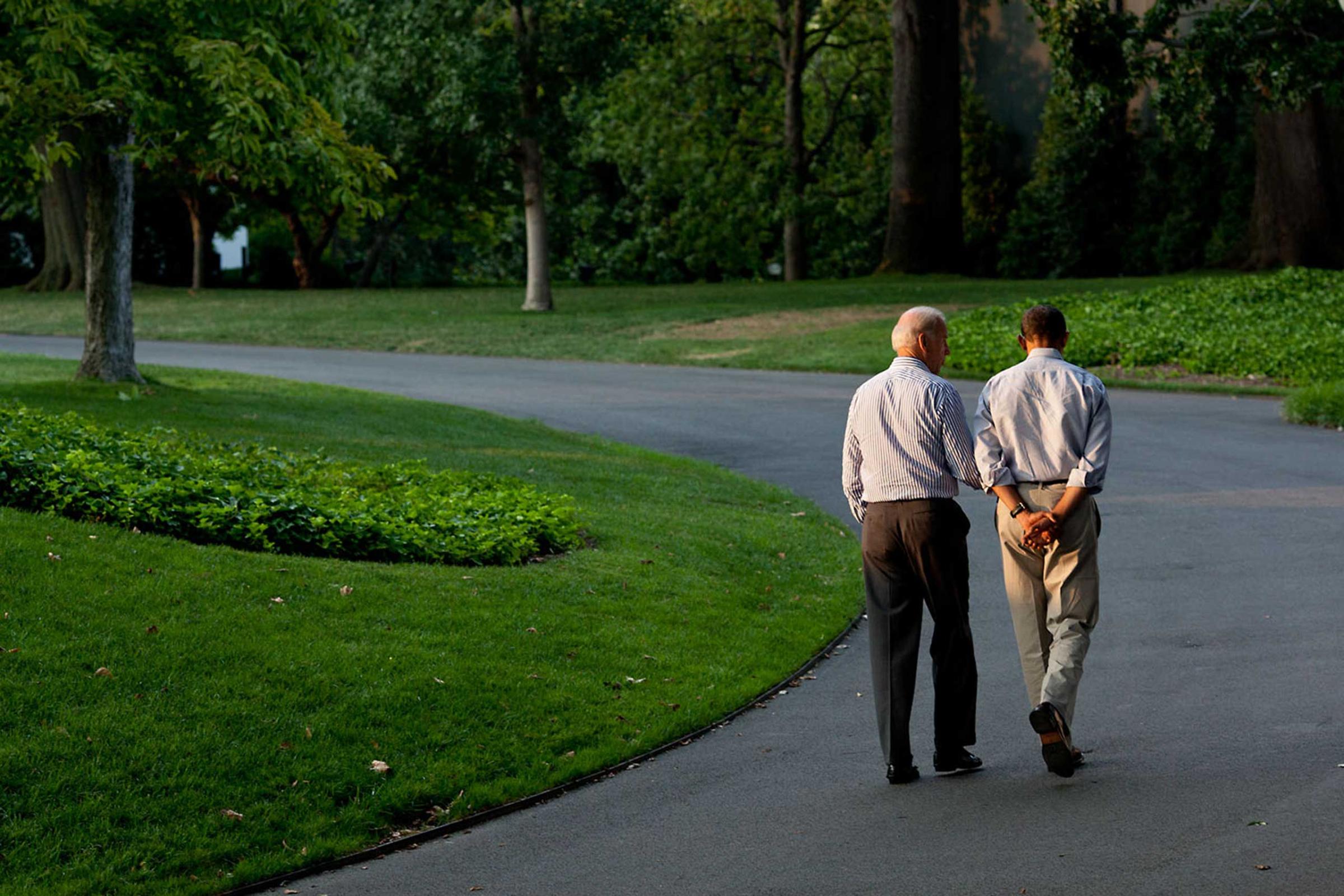 "During a break in the debt limit and deficit negotiations with Congressional leaders, the President walks around the South Lawn drive of the White House with the Vice President on Sunday, July 24, 2011. As they walked, I was trying to catch them where there was one pocket of sunlight seeping through the trees."