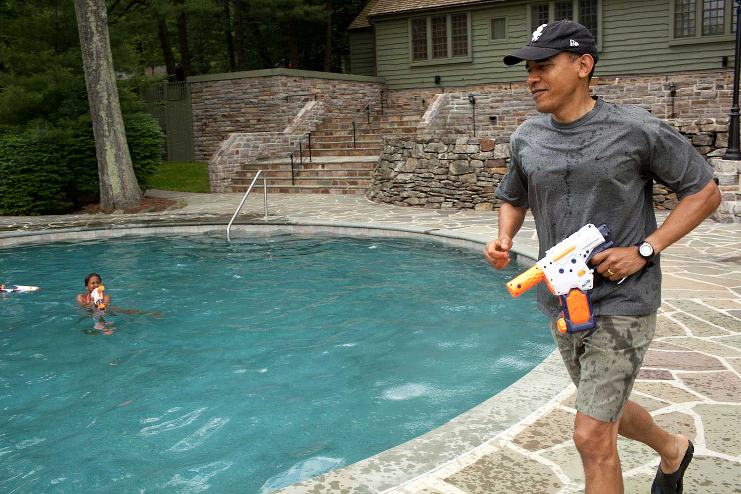 President Obama joins in a water gun fight with daughter Sasha during her 10th birthday celebration at Camp David, Md., June 11, 2011.