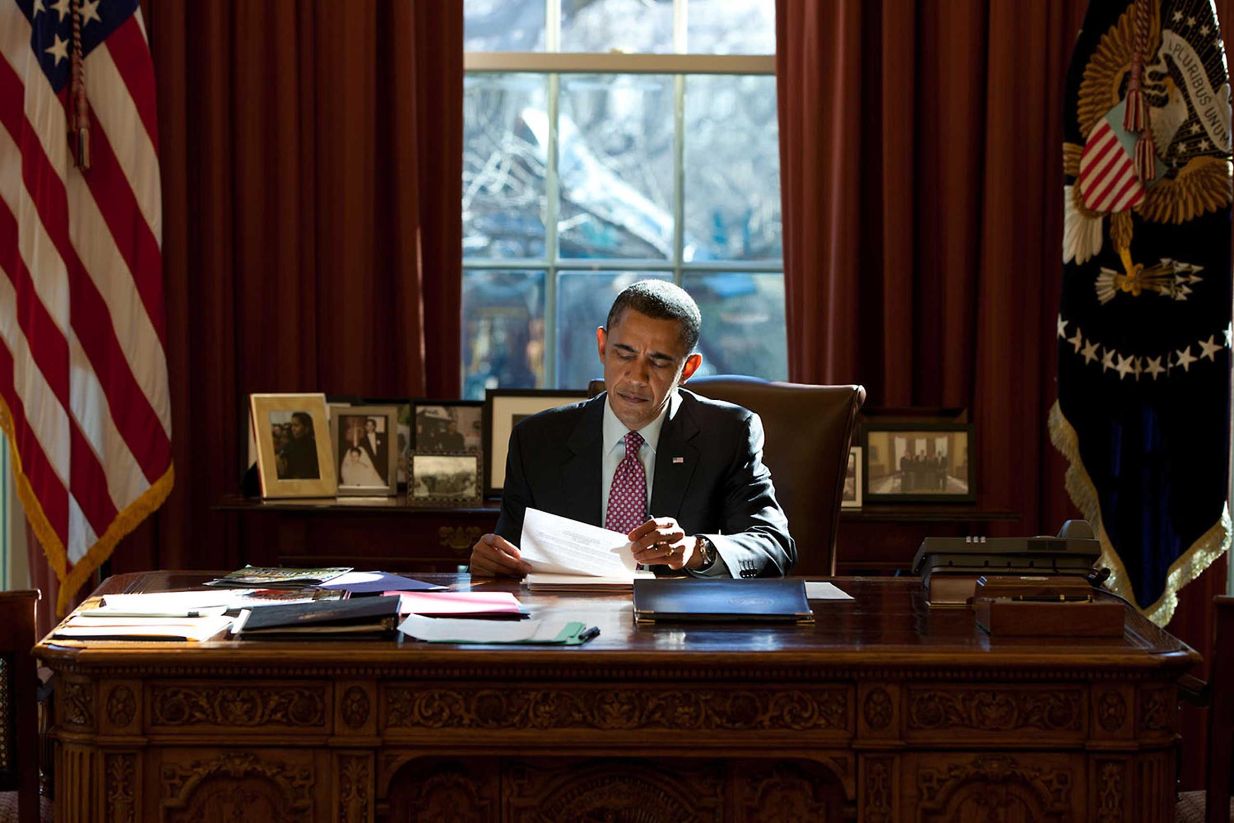 President Obama reads documents while sitting at the Resolute Desk in the Oval Office, Feb. 11, 2011.