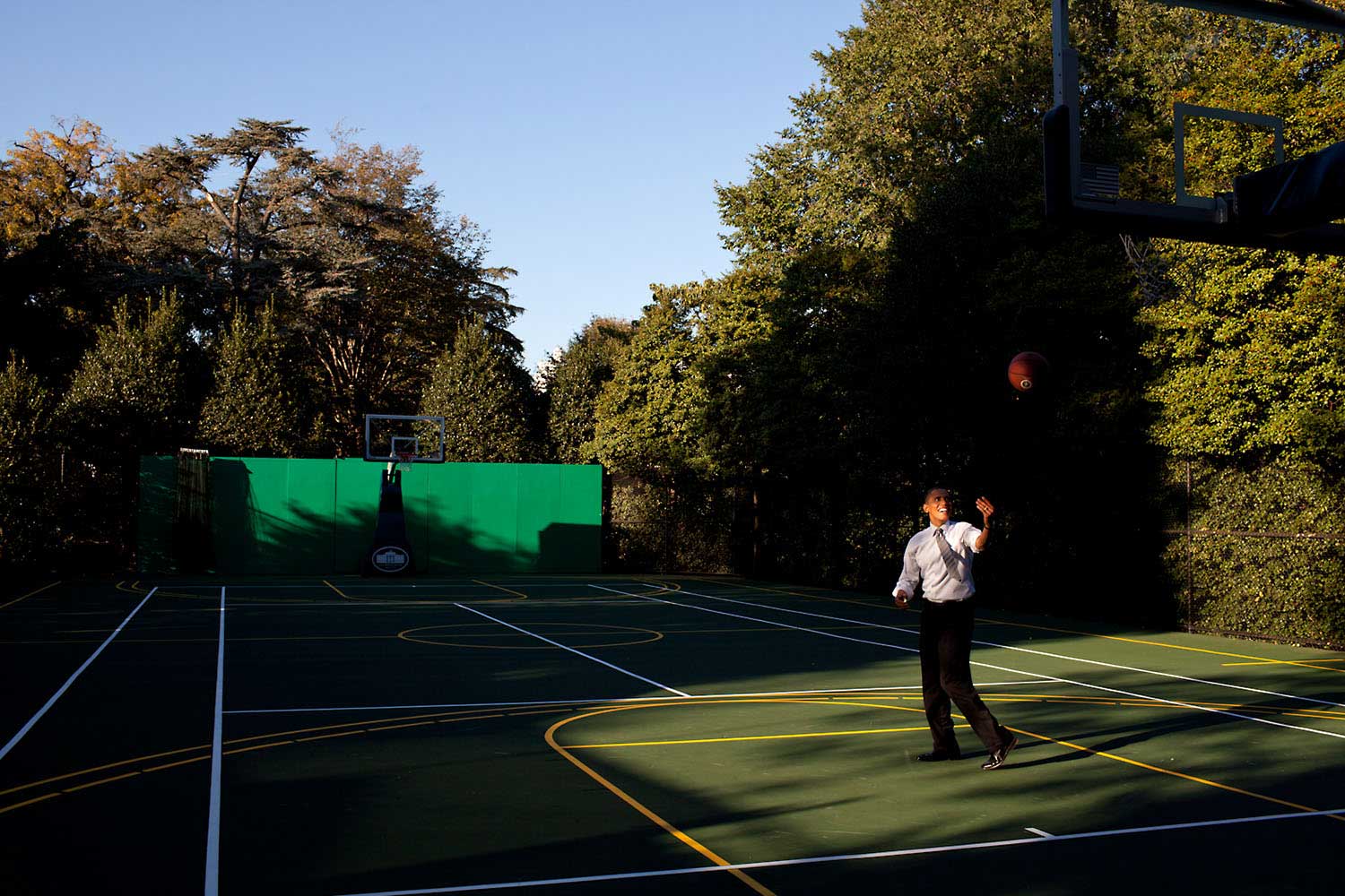 "After a day filled with meetings, the President headed to the White House basketball court to shoot a few baskets with his personal aide Reggie Love, Oct. 13, 2010. Before heading back to the Oval, he flipped the ball towards the rim just where the afternoon light was falling."