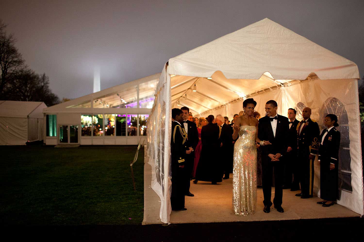 ÒThe President and First Lady wait for Indian Prime Minister SinghÕs motorcade to depart the White House at the conclusion of the first official state dinner for the Obama administration, Nov. 24, 2009. The dinner was held in a tent on the South Lawn. The mist and fog made for an interesting scene, even obscuring the top of the Washington Monument in the background.Ó