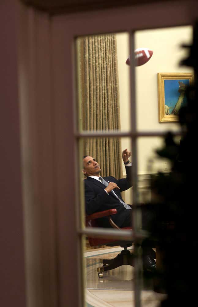 The President throws a football to an aide before a meeting in the Oval Office, April 23, 2009.