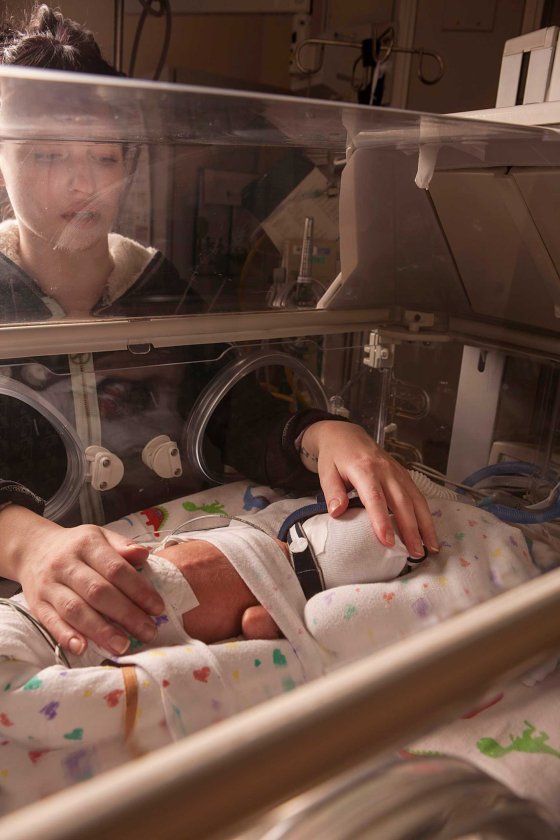 Melissa, David's mother, touches him as he lies in an incubator at the Children’s Hospital of Wisconsin.