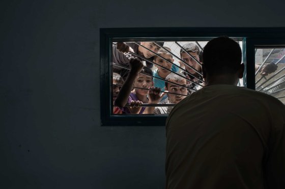 People looking through the window of the Beit Hanoun morgue, in the Gaza Strip, July 9, 2014.