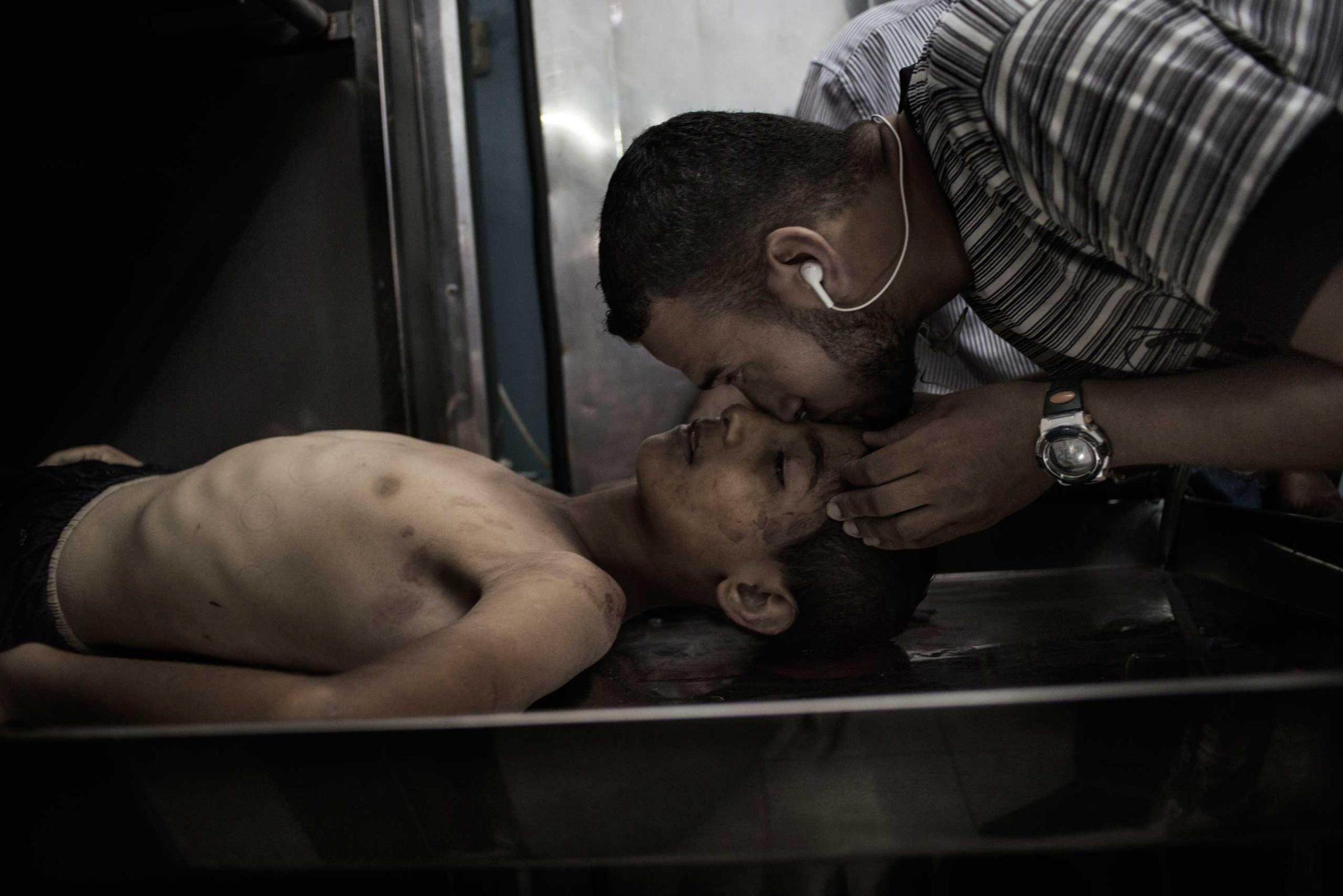 Mohammed Masri, 9, victim of airstrike, is kissed on the forehead by a relative at the morgue of the Beit Hanoun hospital in the Gaza Strip, July 9, 2014.