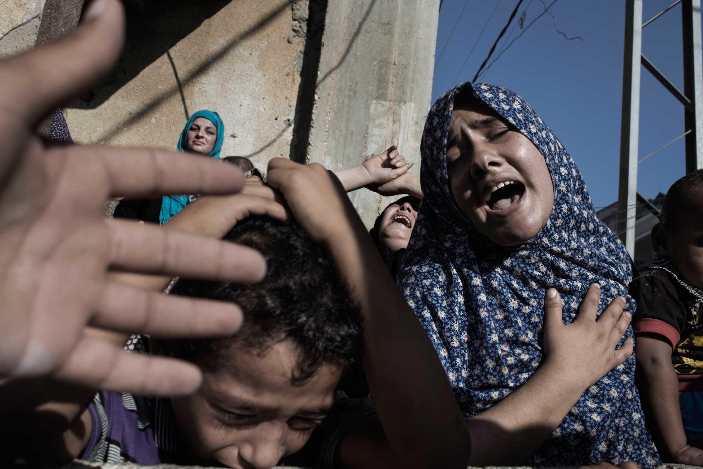 Relatives of four boys from the Bakr family, mourning at their funeral in Gaza City, July 16, 2014.