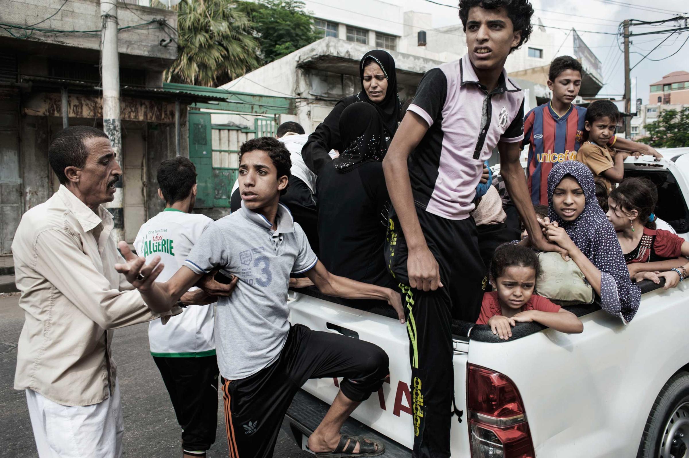 Palestinians prepare to leave Shejaiya during heavy Israeli shelling in Gaza City, July 20, 2014.