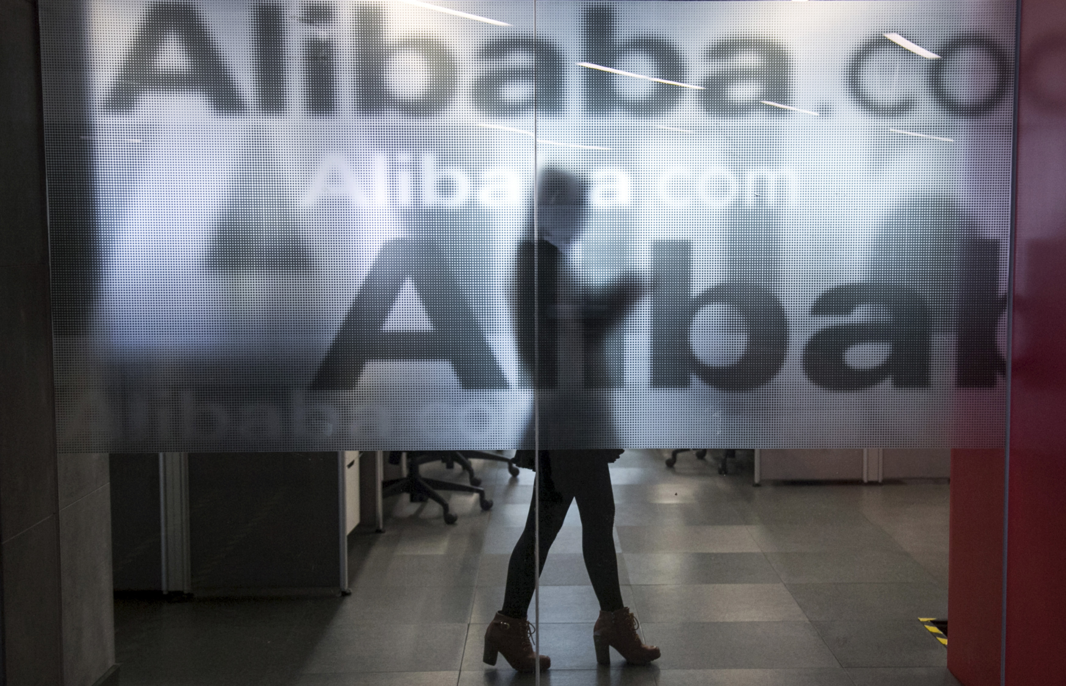 An employee is seen behind a glass wall at Alibaba's headquarters on the outskirts of Hangzhou, China, on April 23, 2014 (Chance Chan—Reuters)