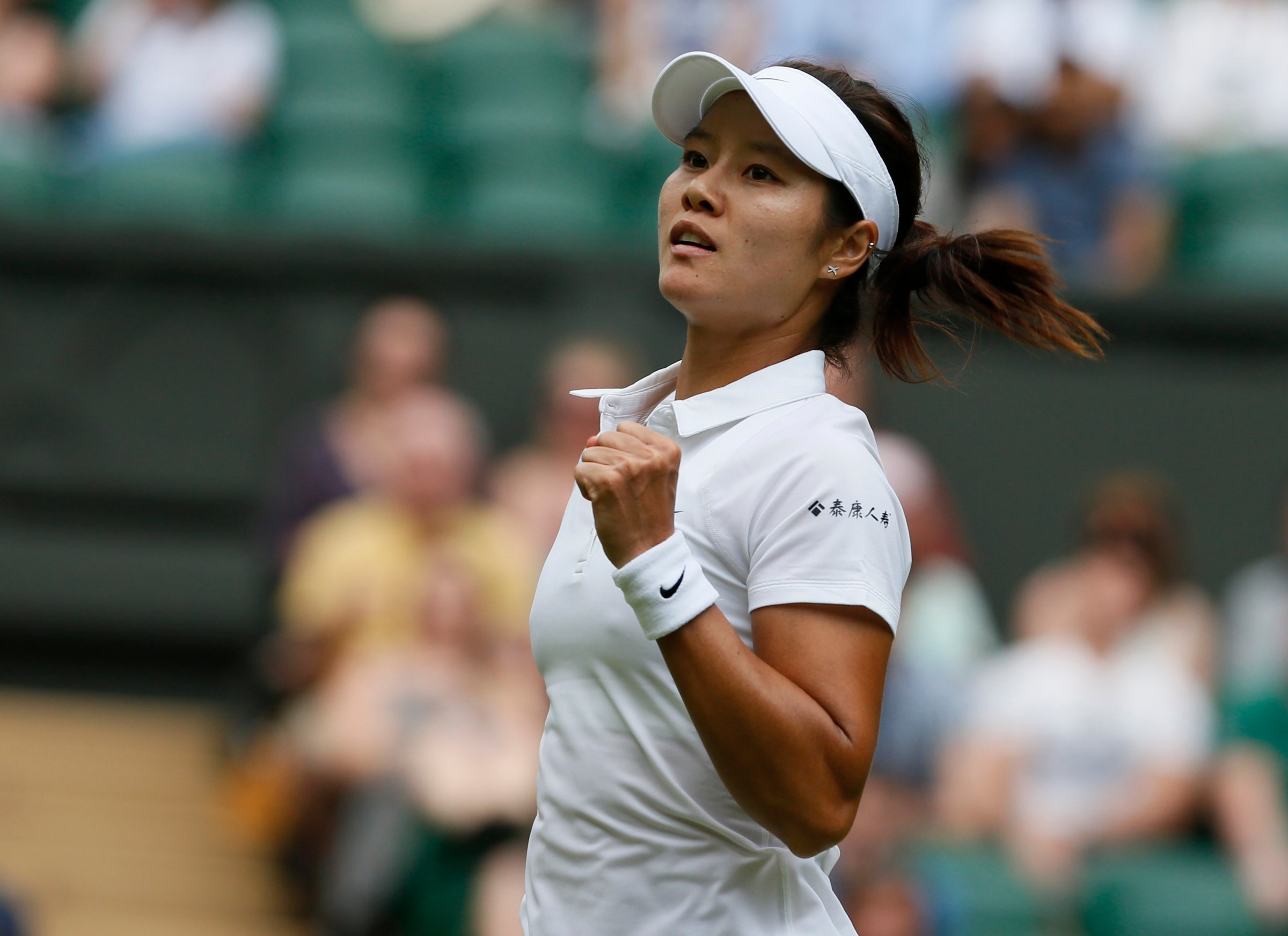 Li Na of China reacts after defeating Paula Kania of Poland in their women's singles tennis match at the Wimbledon Tennis Championships, in London