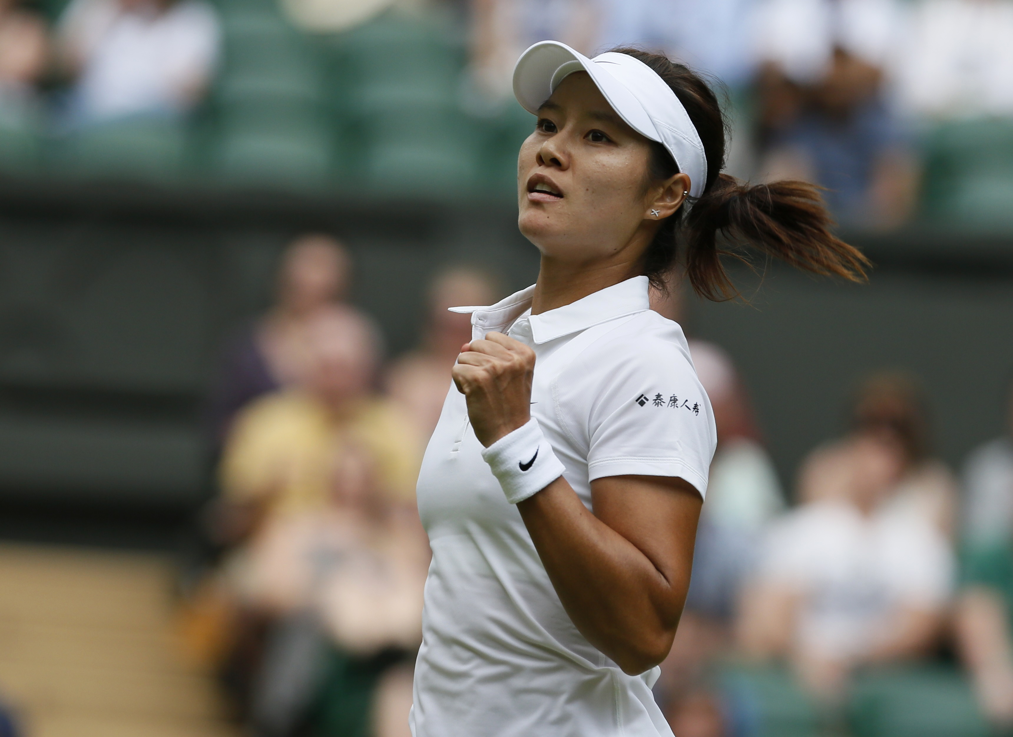 Li Na of China reacts after defeating Paula Kania of Poland in their women's singles tennis match at the Wimbledon Tennis Championships, in London