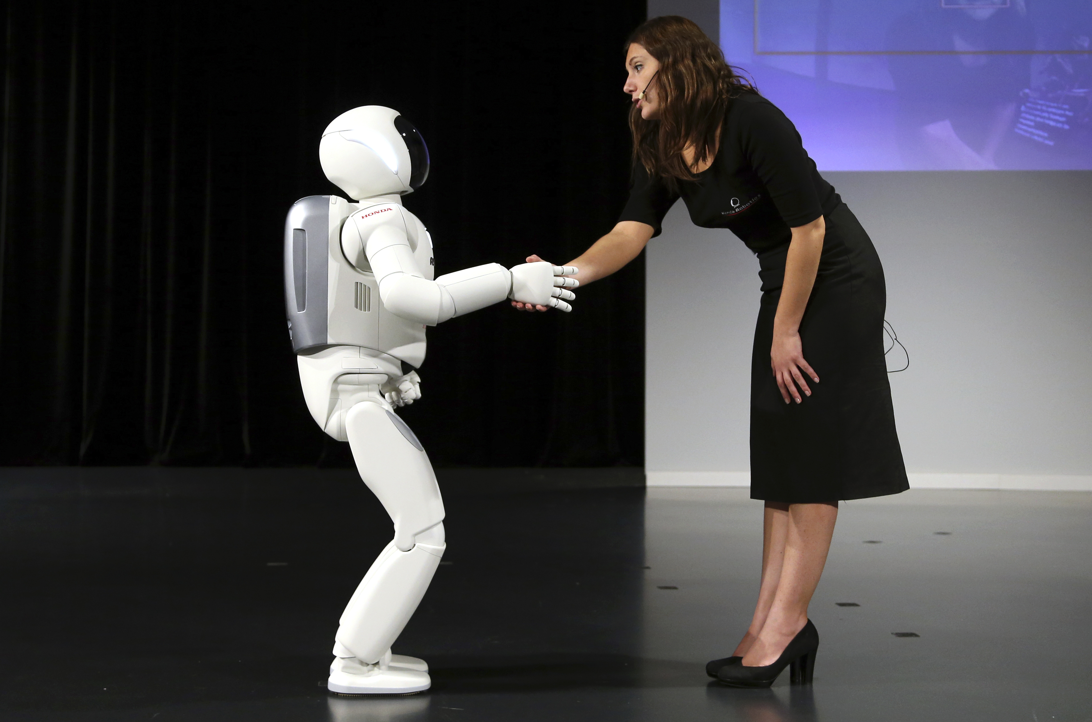 Honda's latest version of the Asimo humanoid robot shakes hands during a presentation in Zaventem near Brussels July 16, 2014. Honda introduced in Belgium an improved version of its Asimo humanoid robot that it says has enhanced intelligence and hand dexterity, and is able to run at a speed of some 9 kilometres per hour (5.6 miles per hour). (Francois Lenoir&mdash;REUTERS)